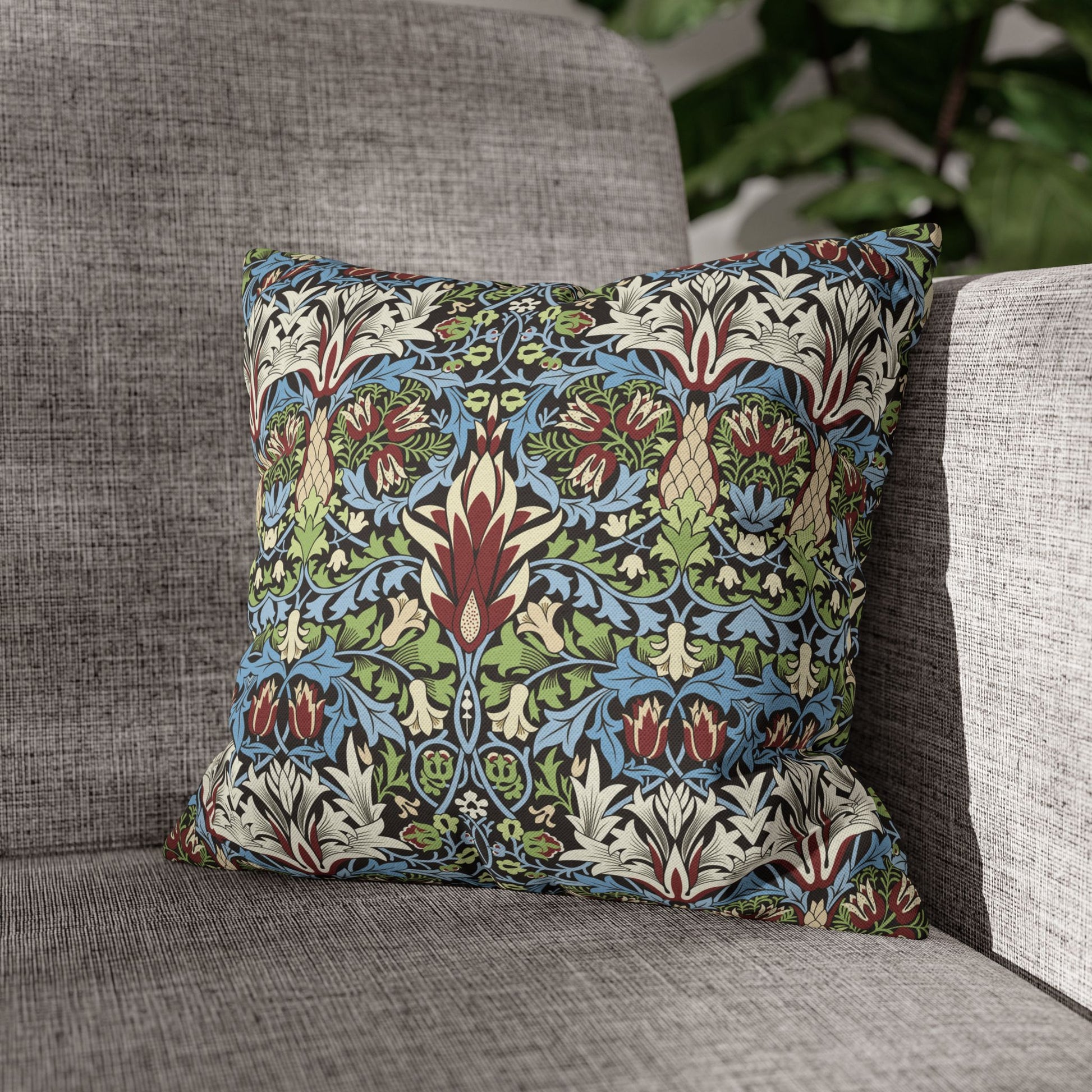 Decorative pillow with floral pattern on a gray sofa - William Morris Snakeshead