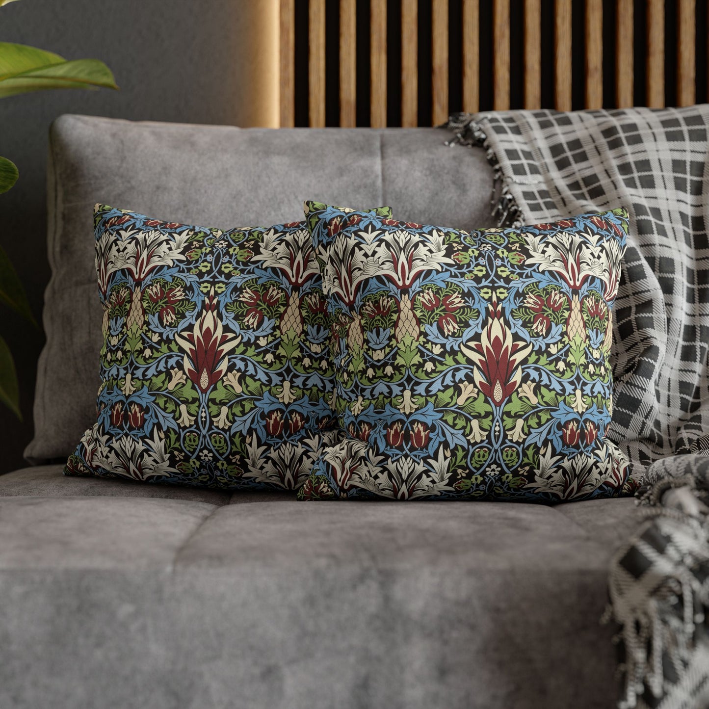 Decorative pillows with a floral pattern on a gray sofa - William Morris Snakeshead