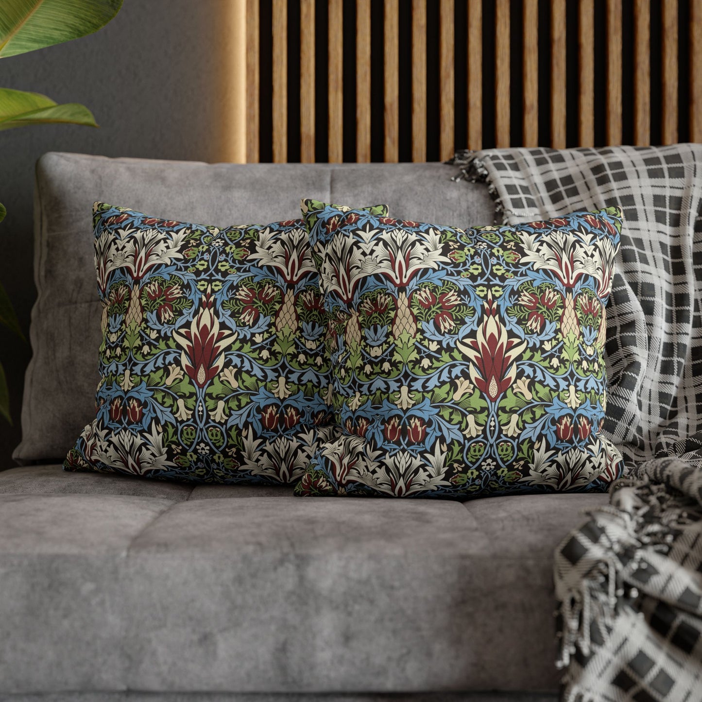 Decorative pillows with a floral pattern on a gray sofa - William Morris Snakeshead