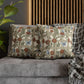 Decorative pillows with floral patterns on a gray sofa against a wooden slat wall.
