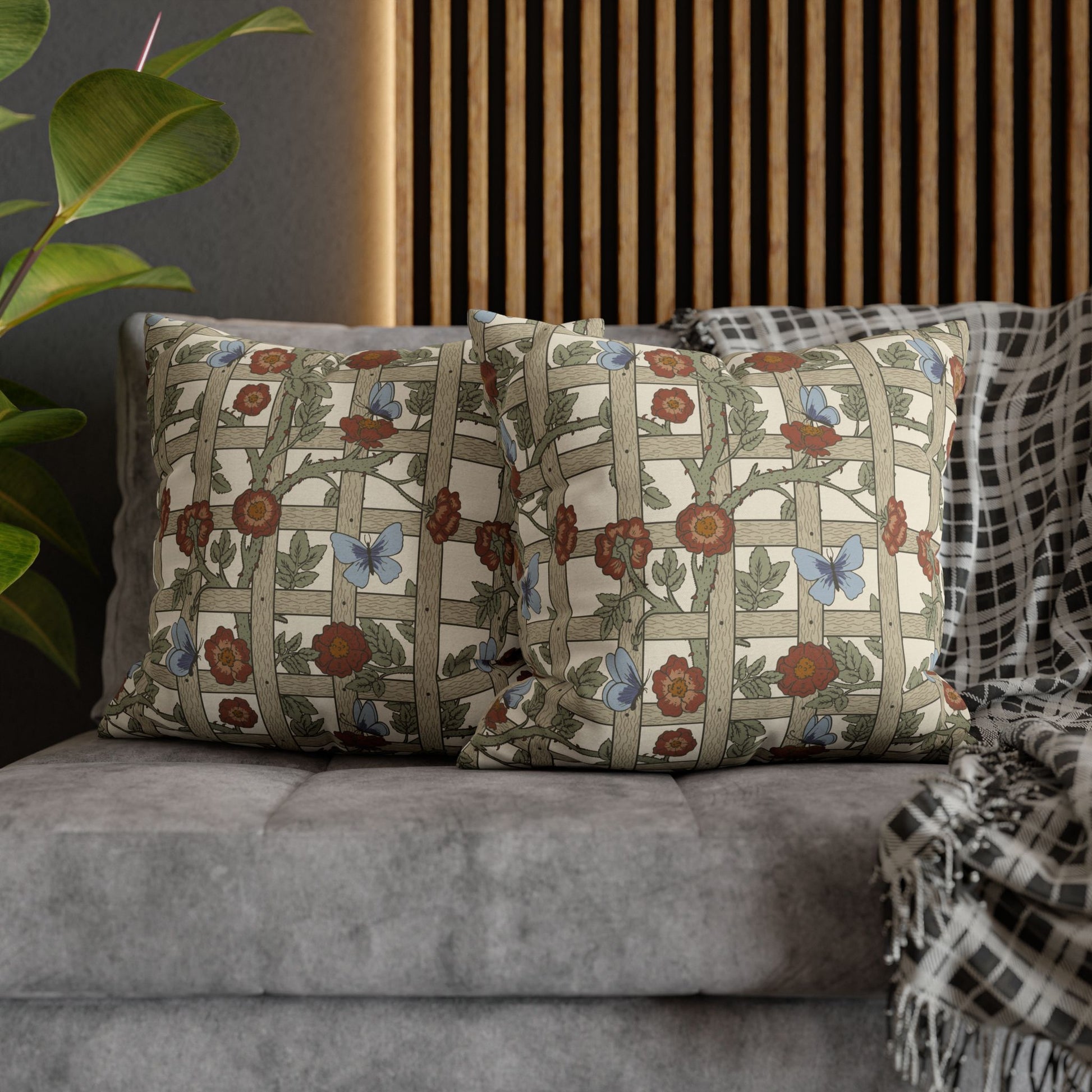 Decorative pillows with floral patterns on a gray sofa against a wooden slat wall.
