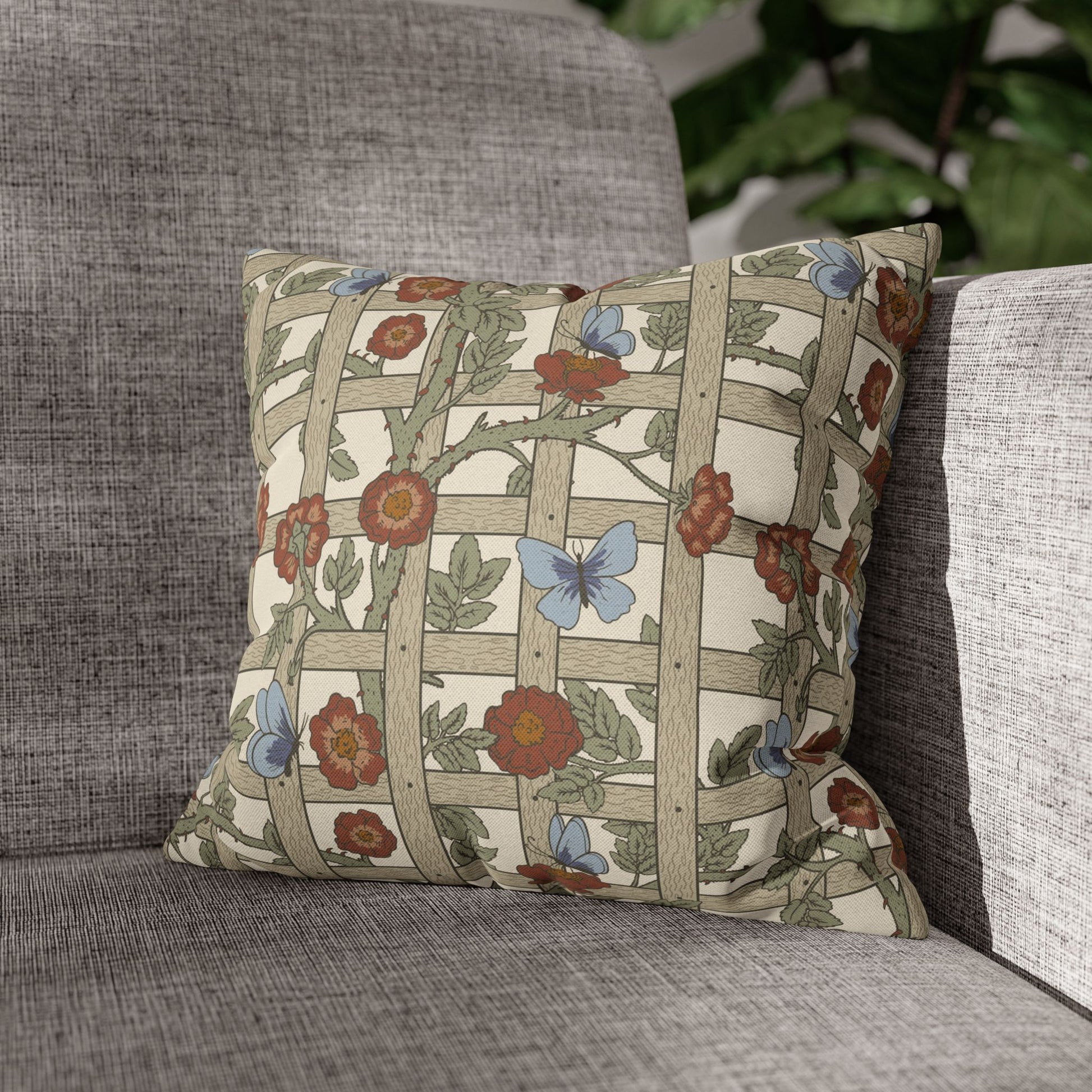 Decorative pillow with floral and butterfly pattern on a gray sofa