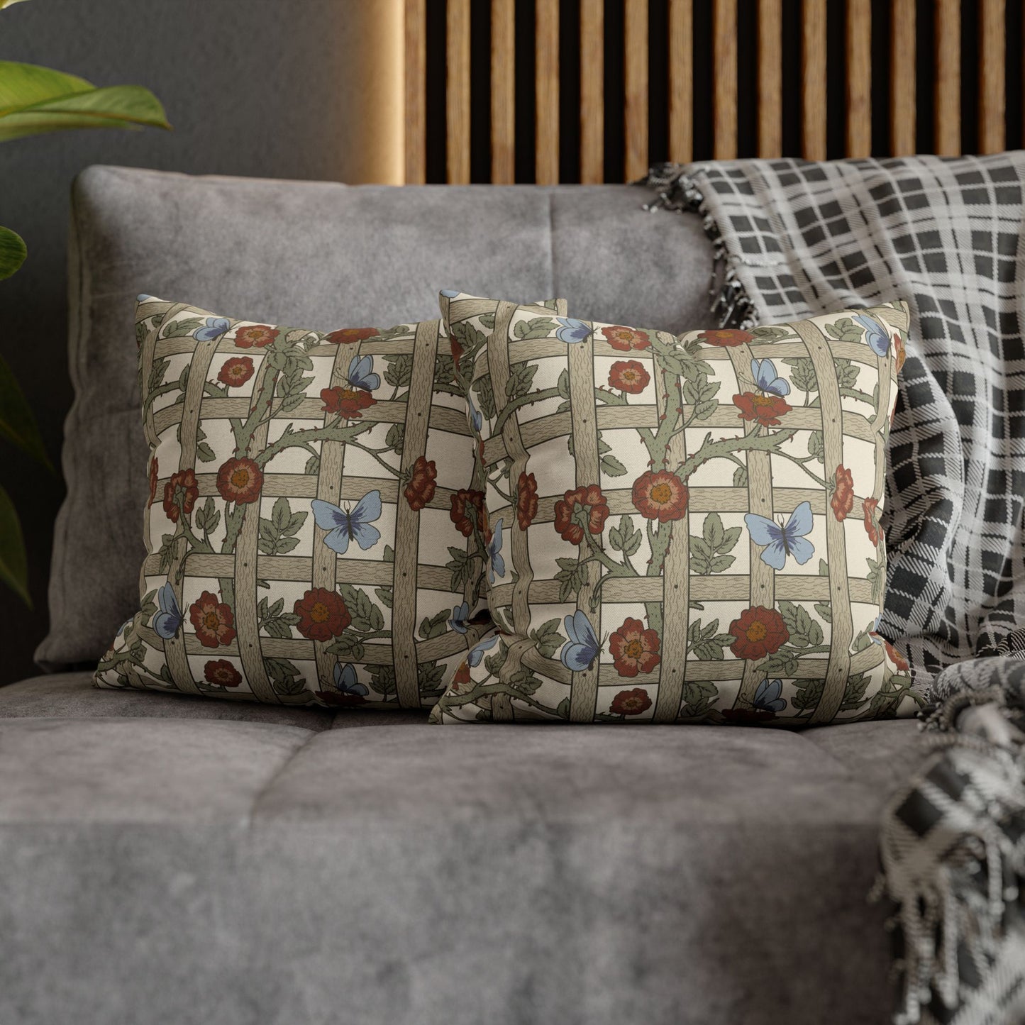 Decorative pillows with floral and butterfly pattern on a gray sofa.