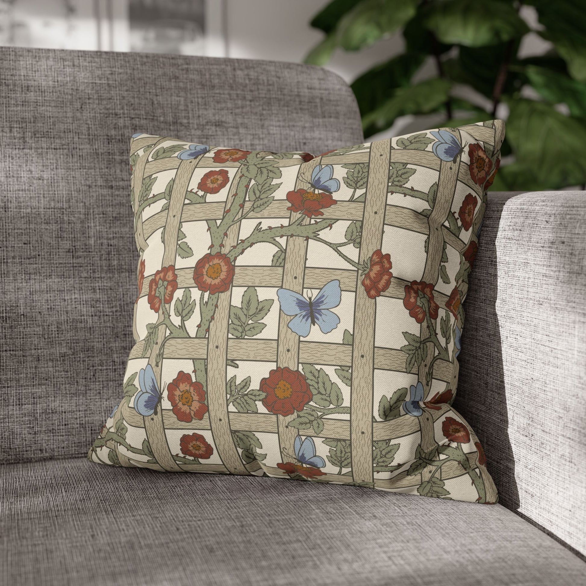 Decorative pillow with floral and butterfly pattern on a gray sofa