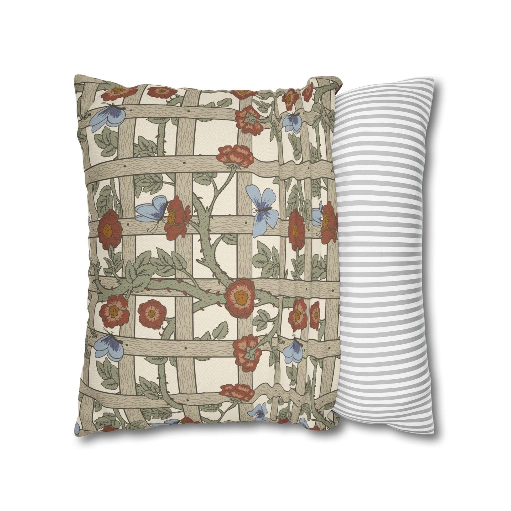 Decorative pillow with floral and lattice design next to a striped pillow on a white background