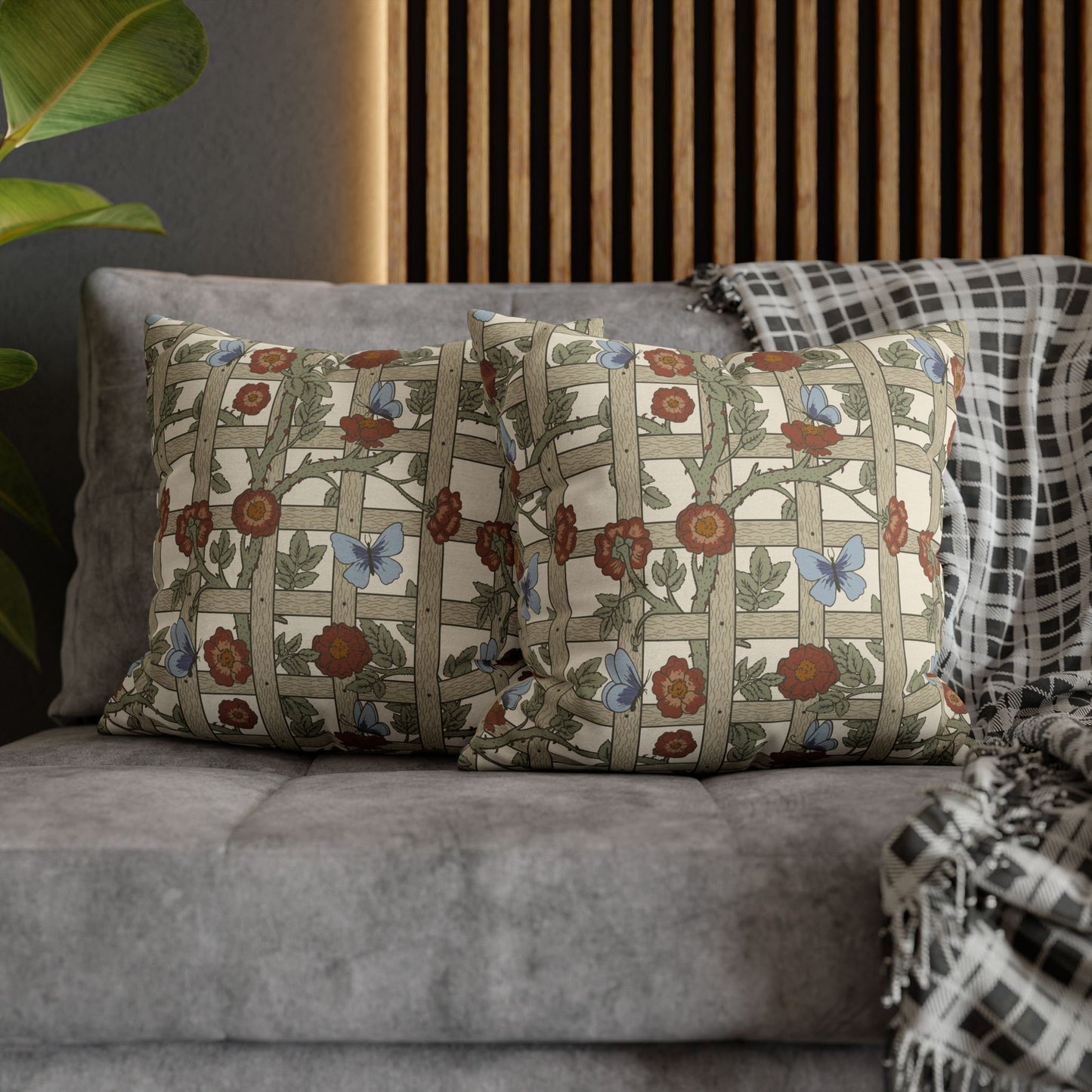 Decorative pillows with floral patterns on a gray sofa against a wooden panel background.