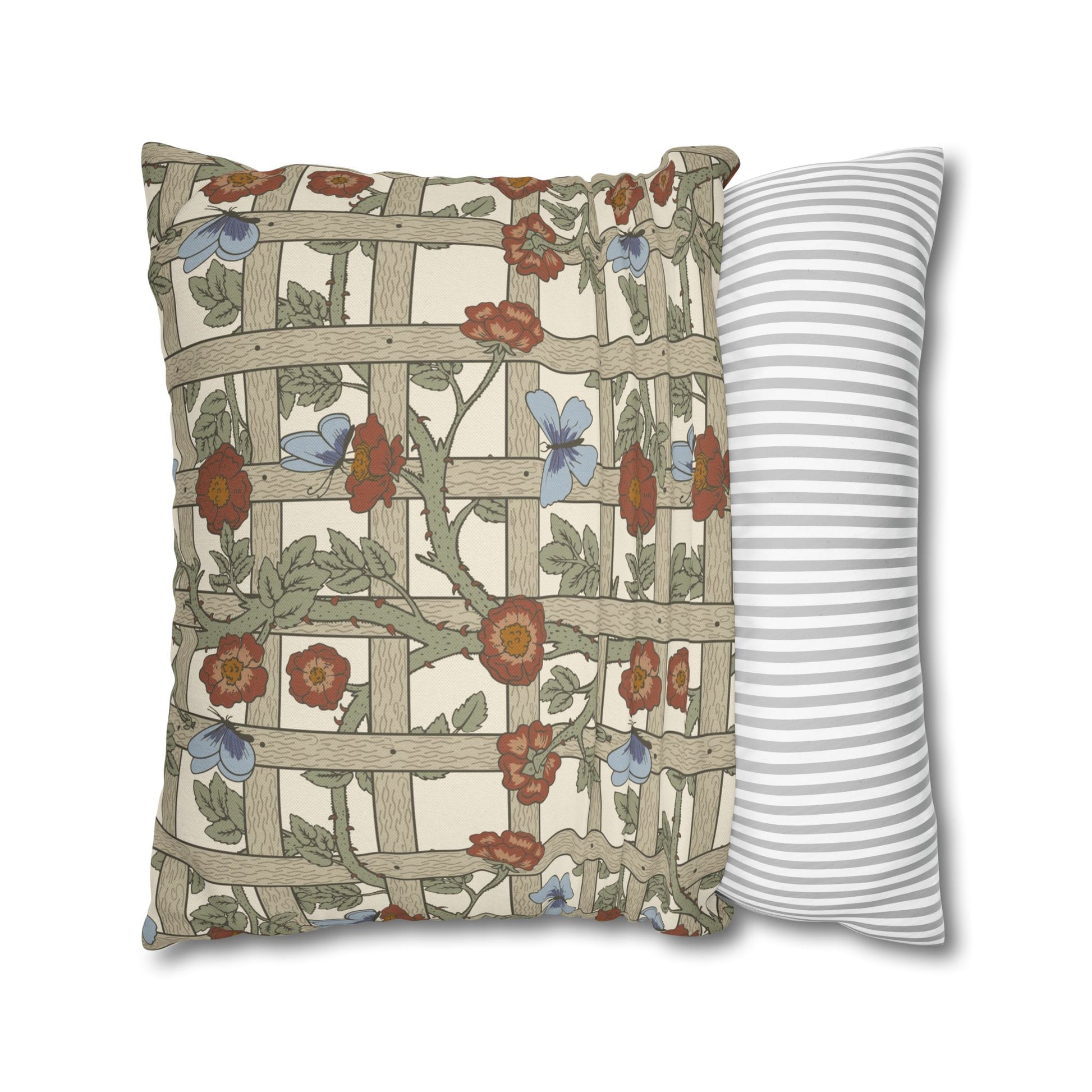 Decorative pillow with floral and lattice design next to a striped pillow on a white background