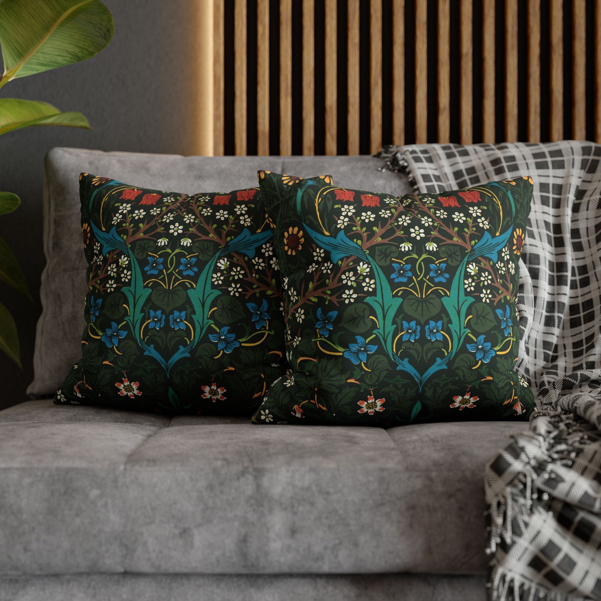 Decorative pillows with floral patterns on a gray sofa against a wooden headboard _ William Morris Tulip