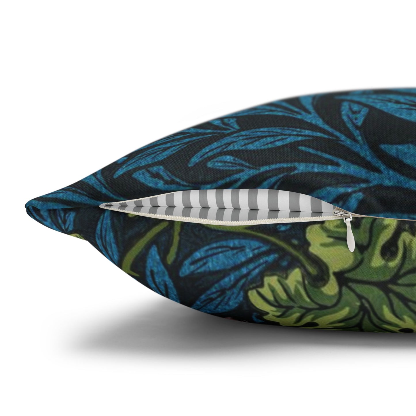 Decorative pillow with a blue and green leaf pattern on a white background