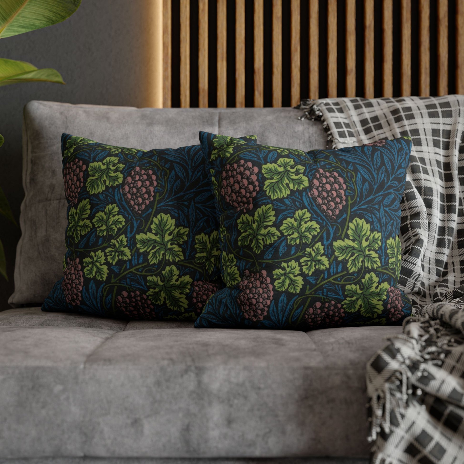 Floral patterned cushions on a gray sofa with a wooden headboard in the background.