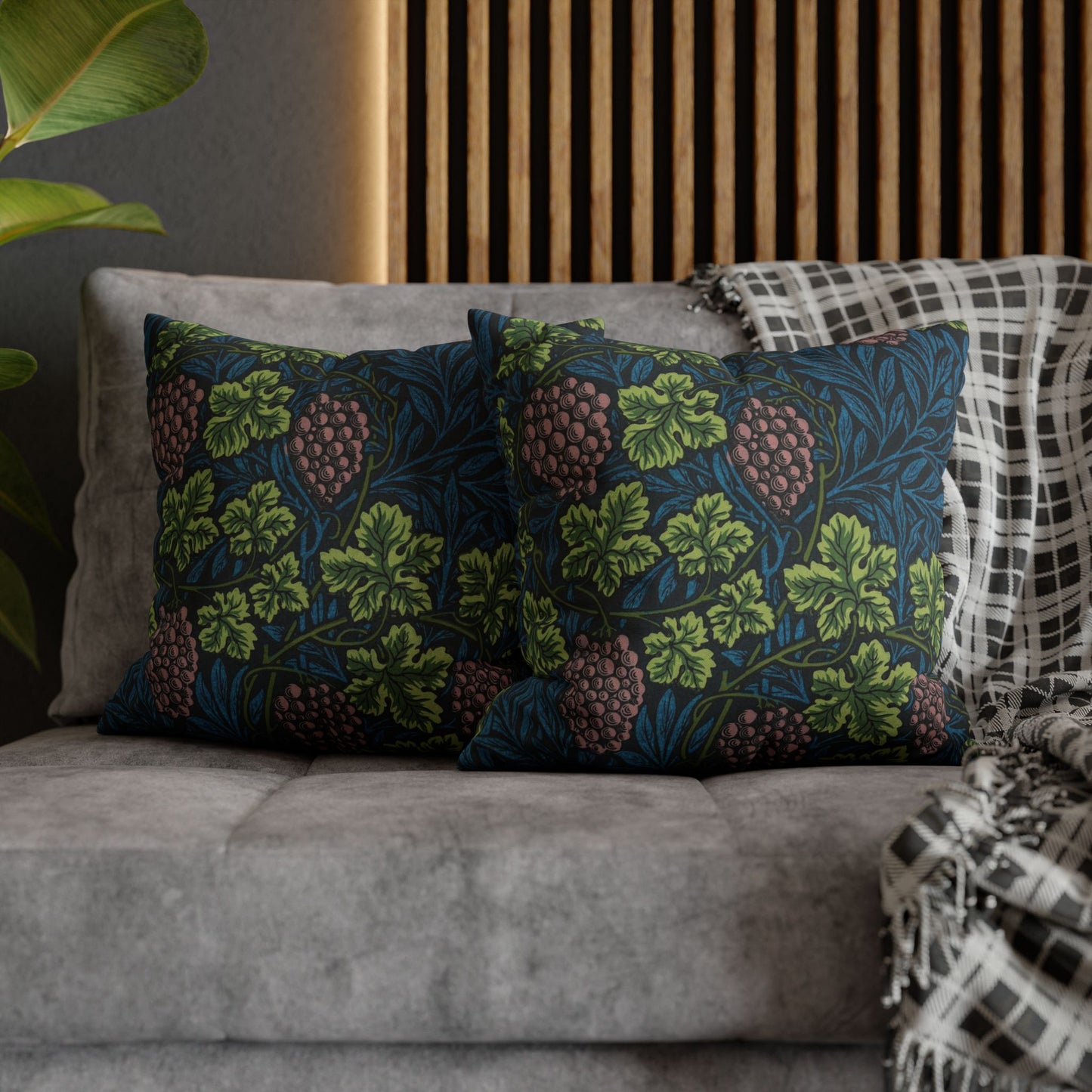 Decorative pillows with floral patterns on a gray sofa against a wooden headboard.