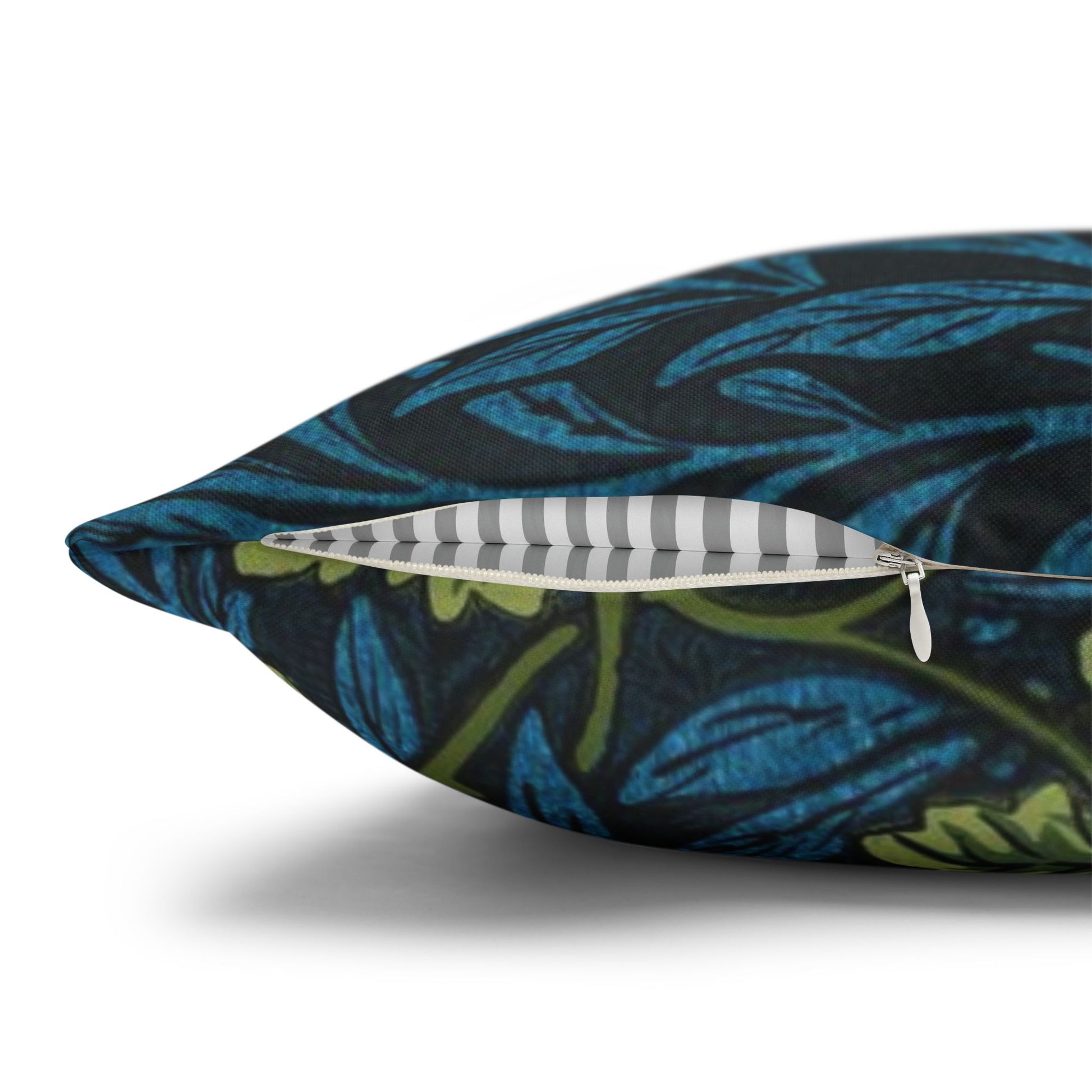 Decorative pillow with a blue and green leaf pattern on a white background