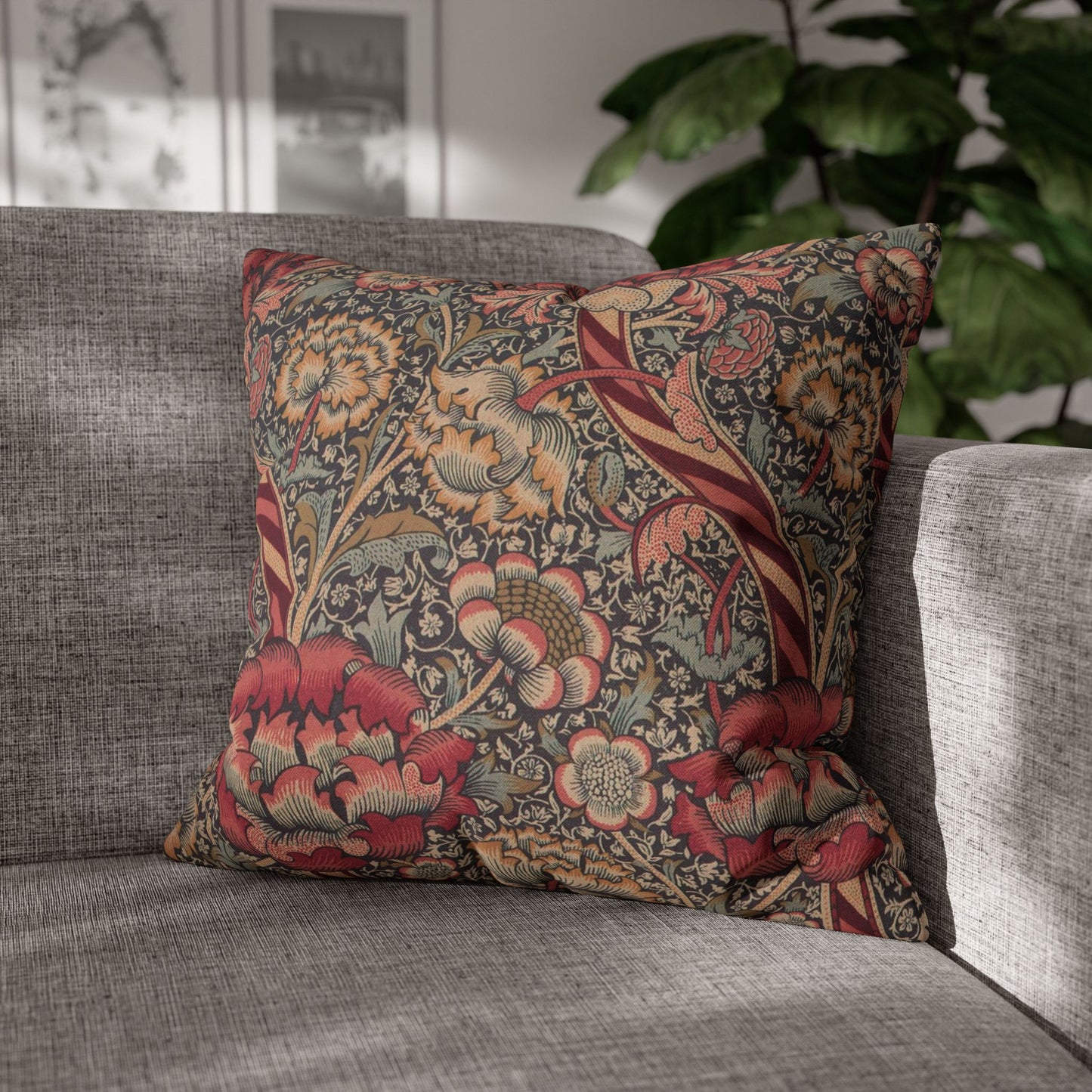 Decorative floral pillow on a gray sofa with a blurred indoor background