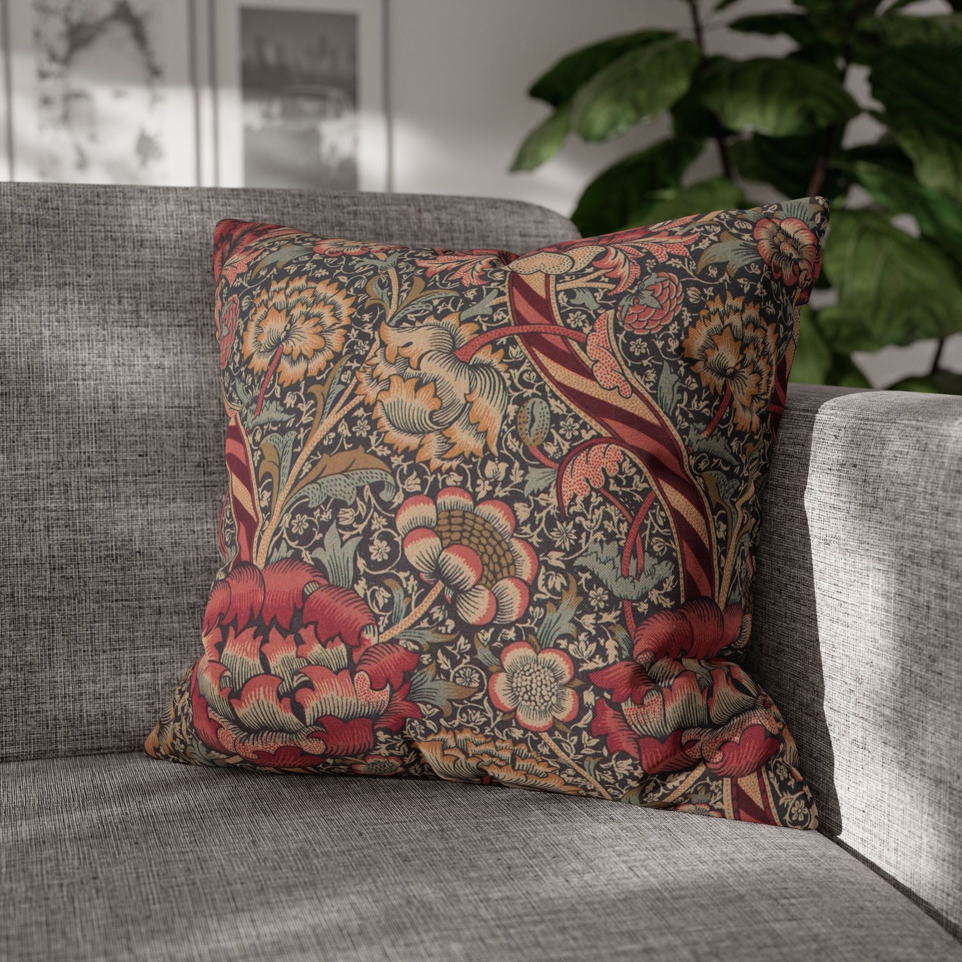 Decorative floral pillow on a gray sofa with a blurred indoor background
