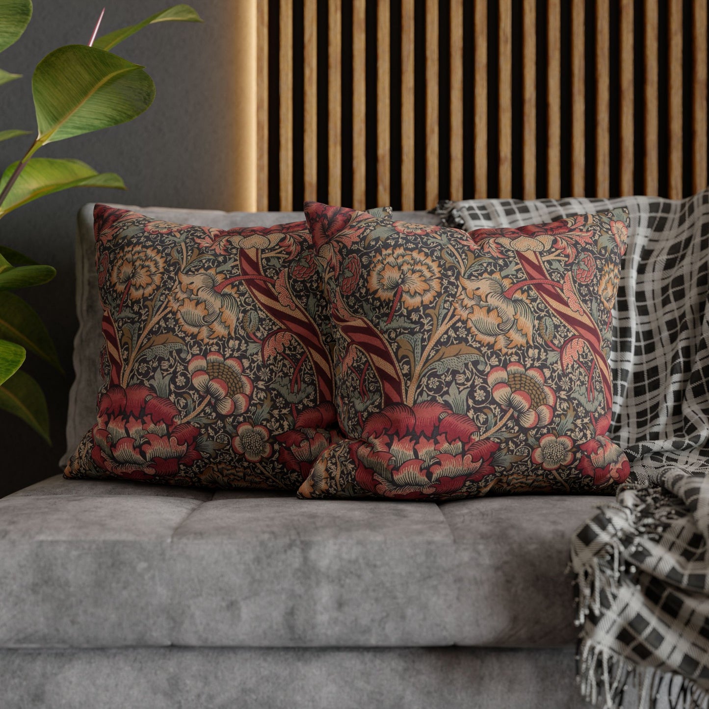 Decorative pillows with floral patterns on a gray sofa.