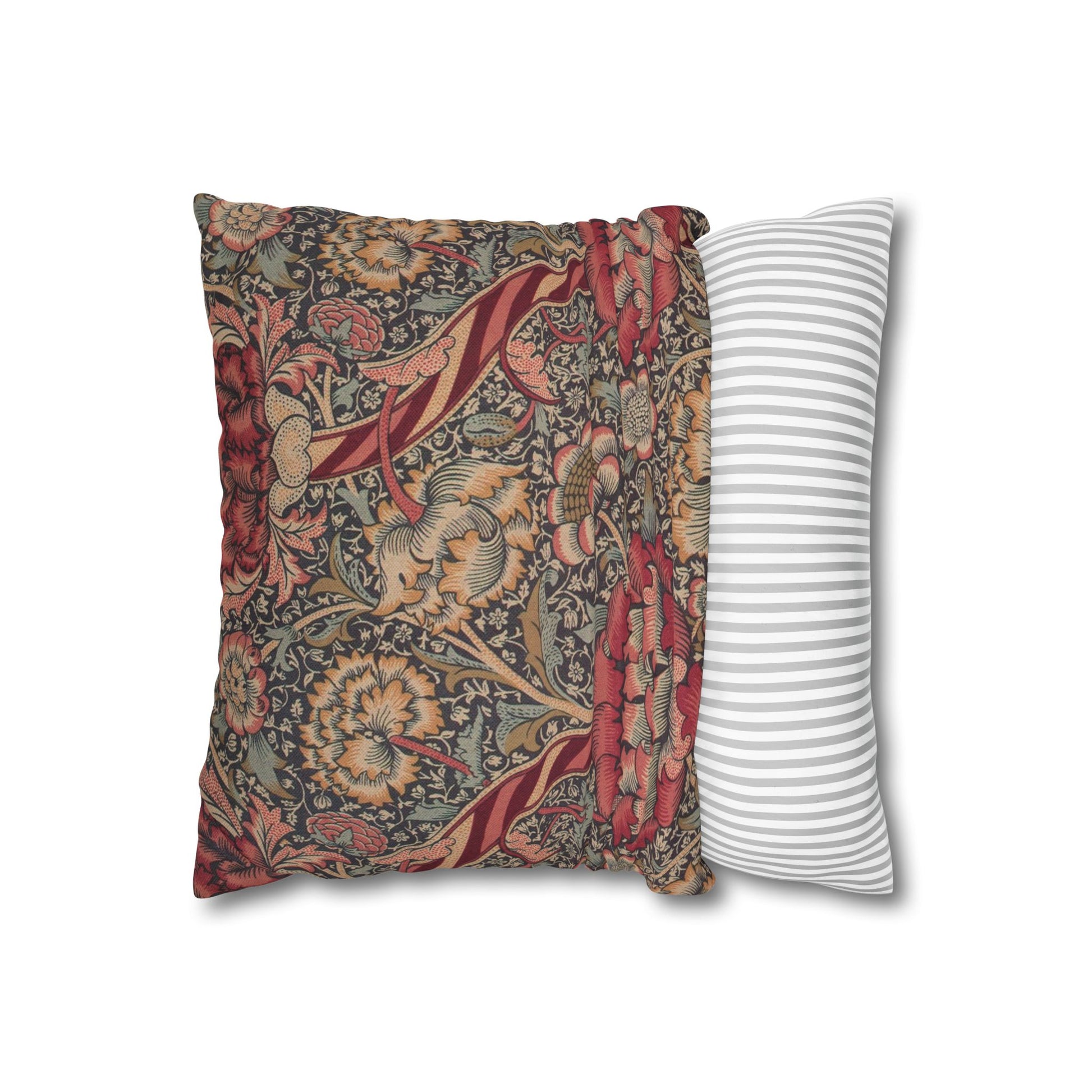 Decorative pillow with floral pattern next to a striped pillow on a white background