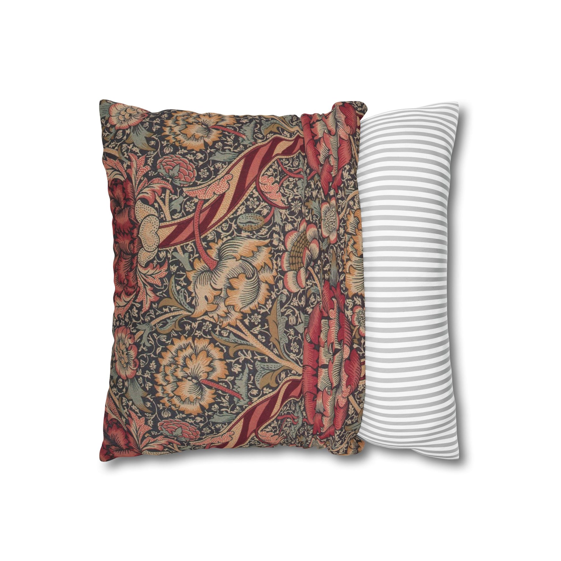 Decorative pillow with floral pattern next to a striped pillow on a white background