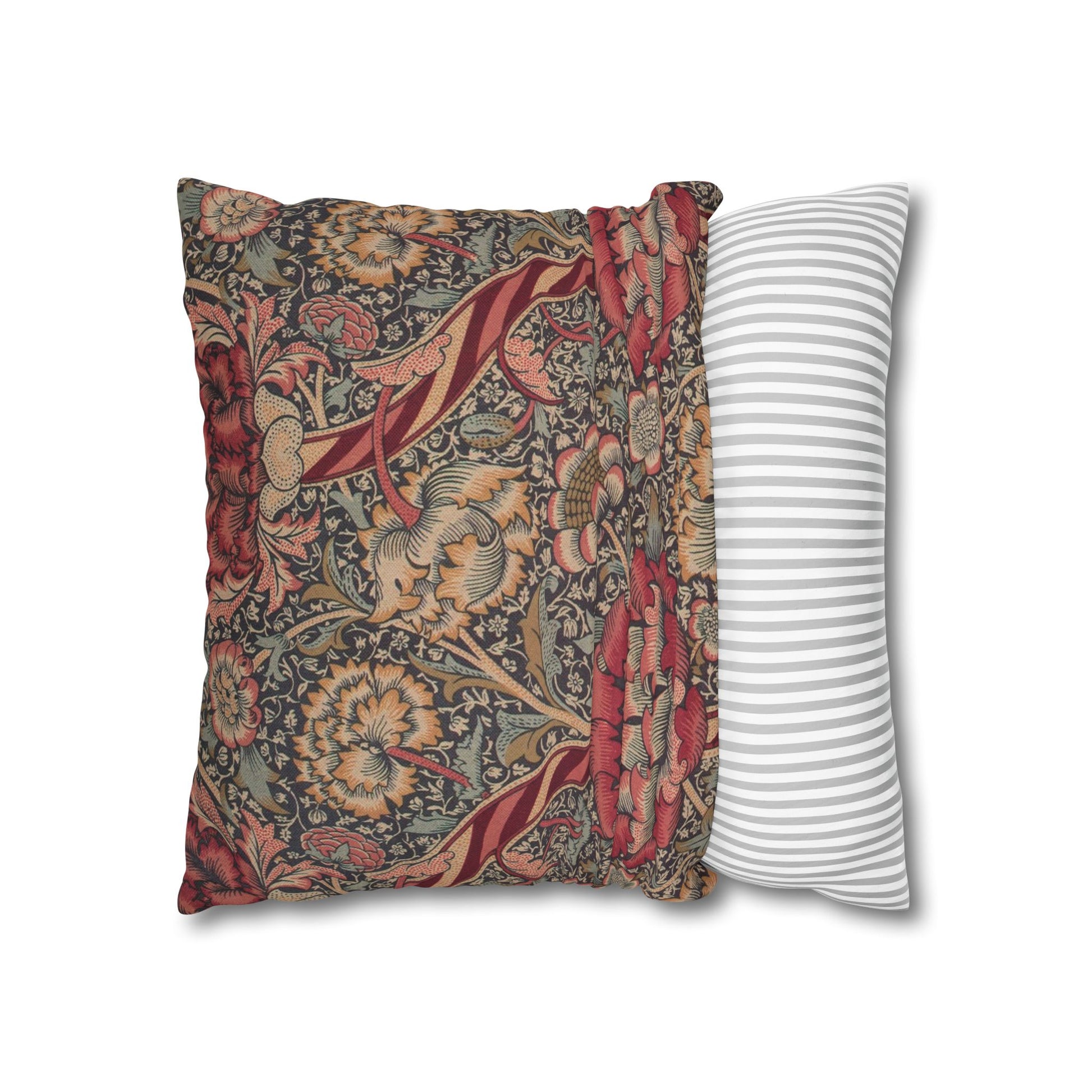 Decorative pillow with floral pattern next to a striped pillow on a white background