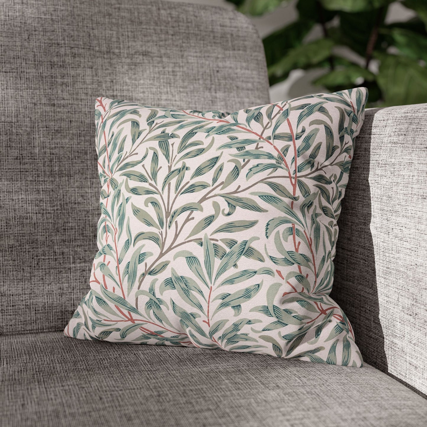 Decorative pillow with leaf pattern on a gray sofa