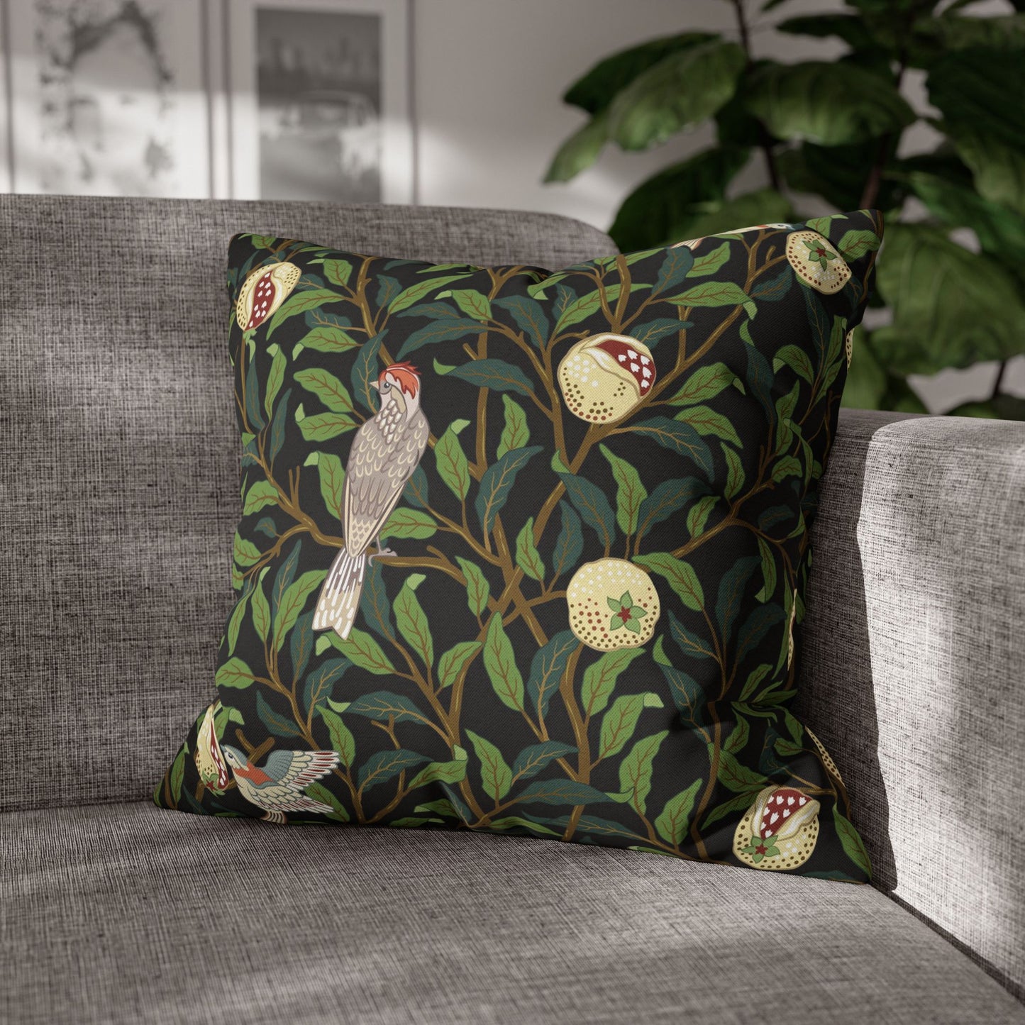 Decorative pillow with bird and leaf pattern on a gray sofa