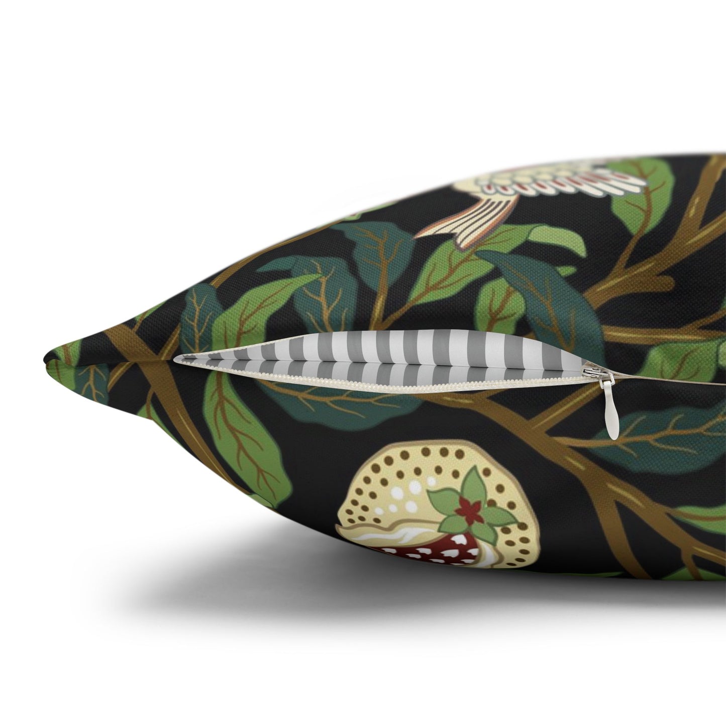 Decorative pillow with nature-themed design featuring leaves and a bird on a black background.