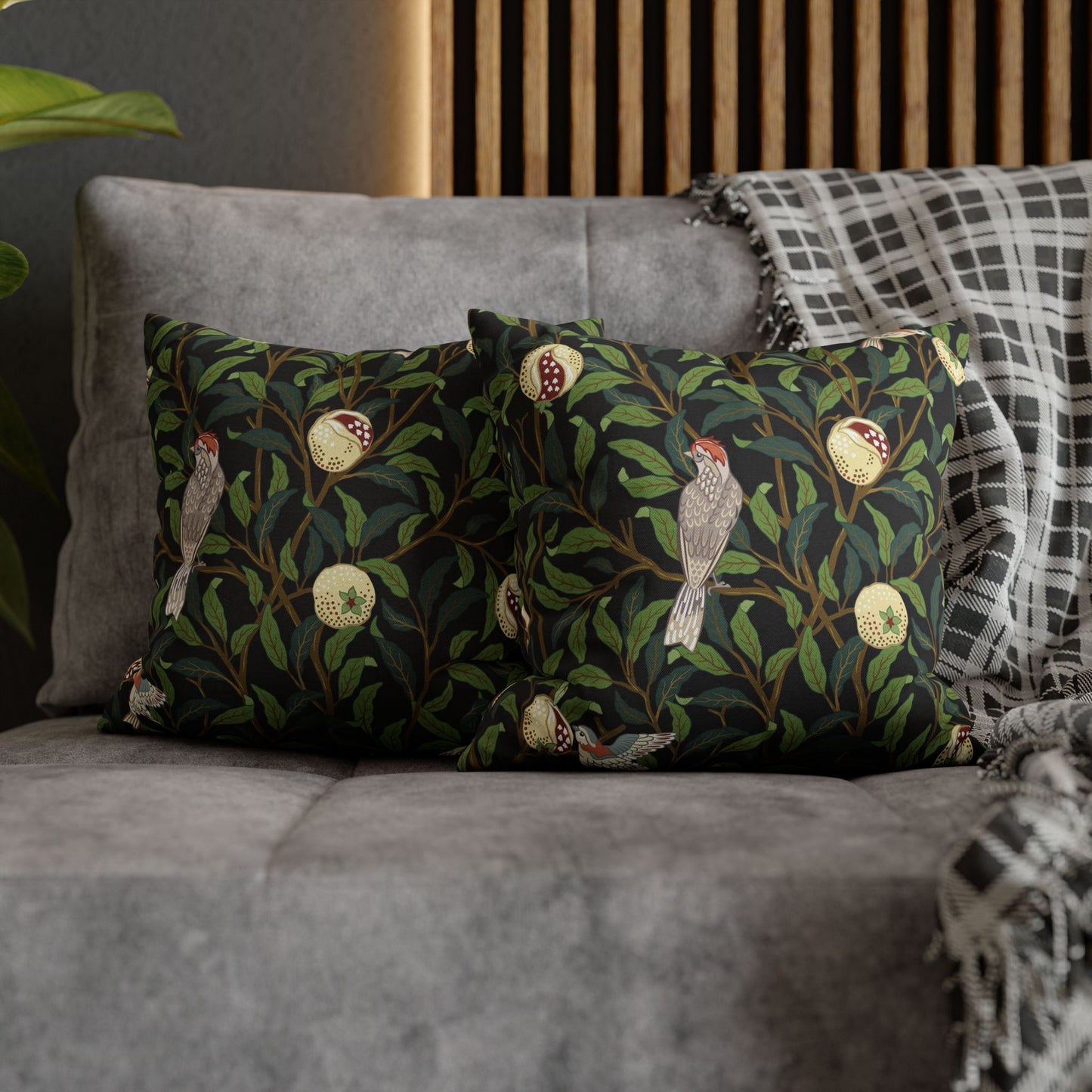 Decorative pillows with bird and floral pattern on a gray sofa.