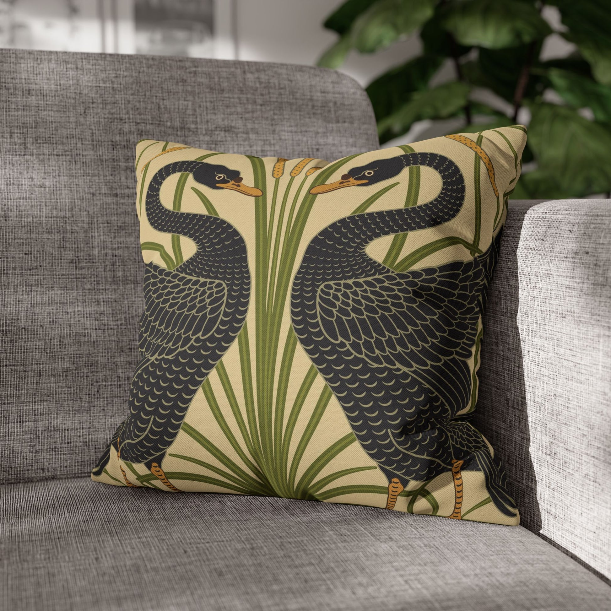 Decorative pillow with bird design on a gray sofa