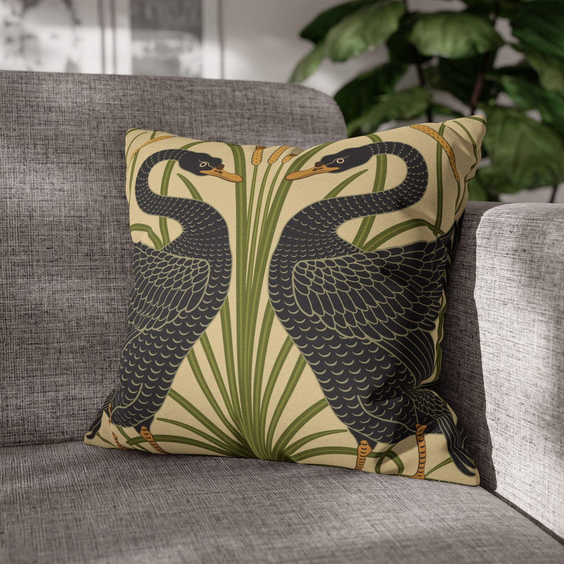 Decorative pillow with bird design on a gray sofa