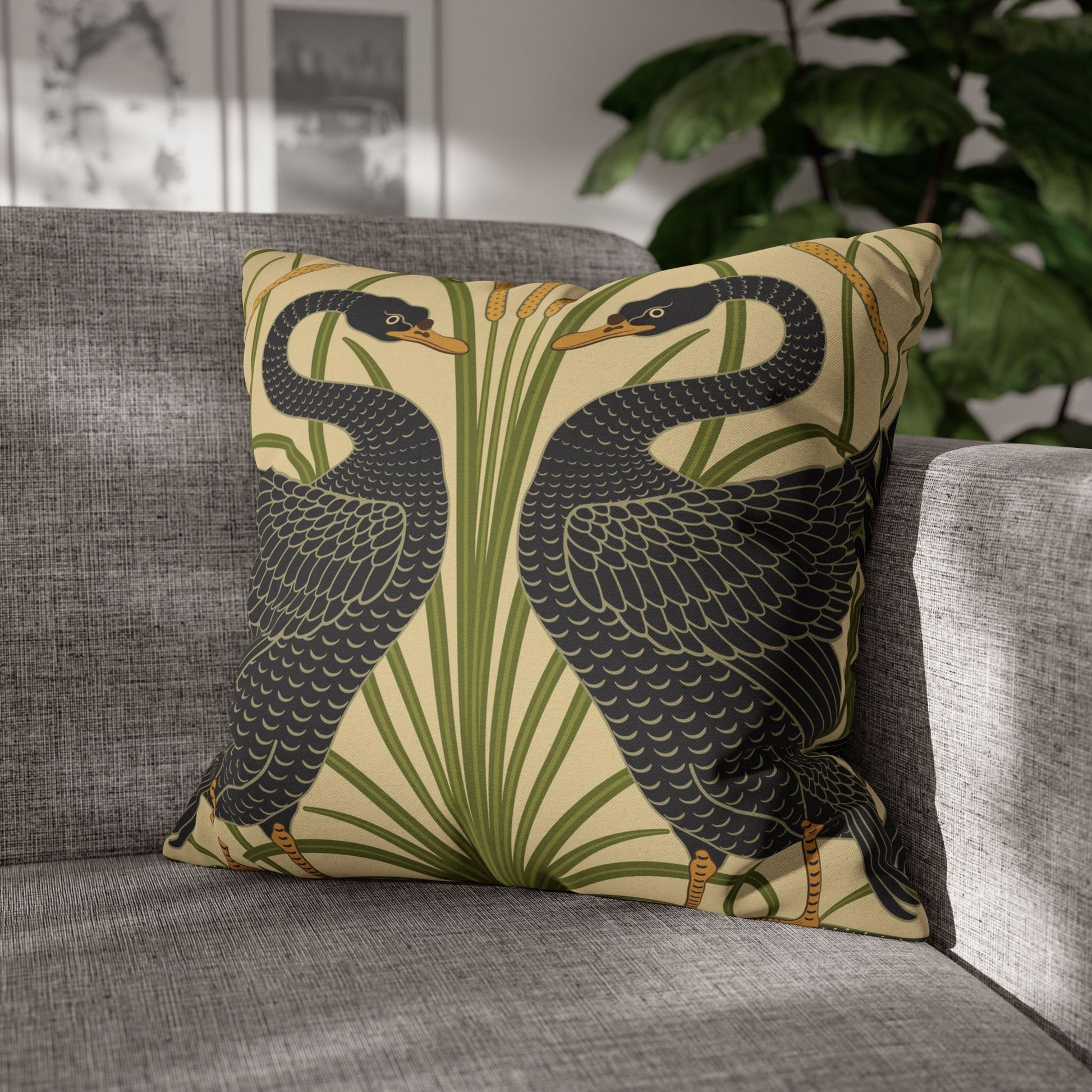 Decorative pillow with bird design on a gray sofa
