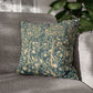 Floral patterned pillow on a gray sofa with a blurred plant in the background