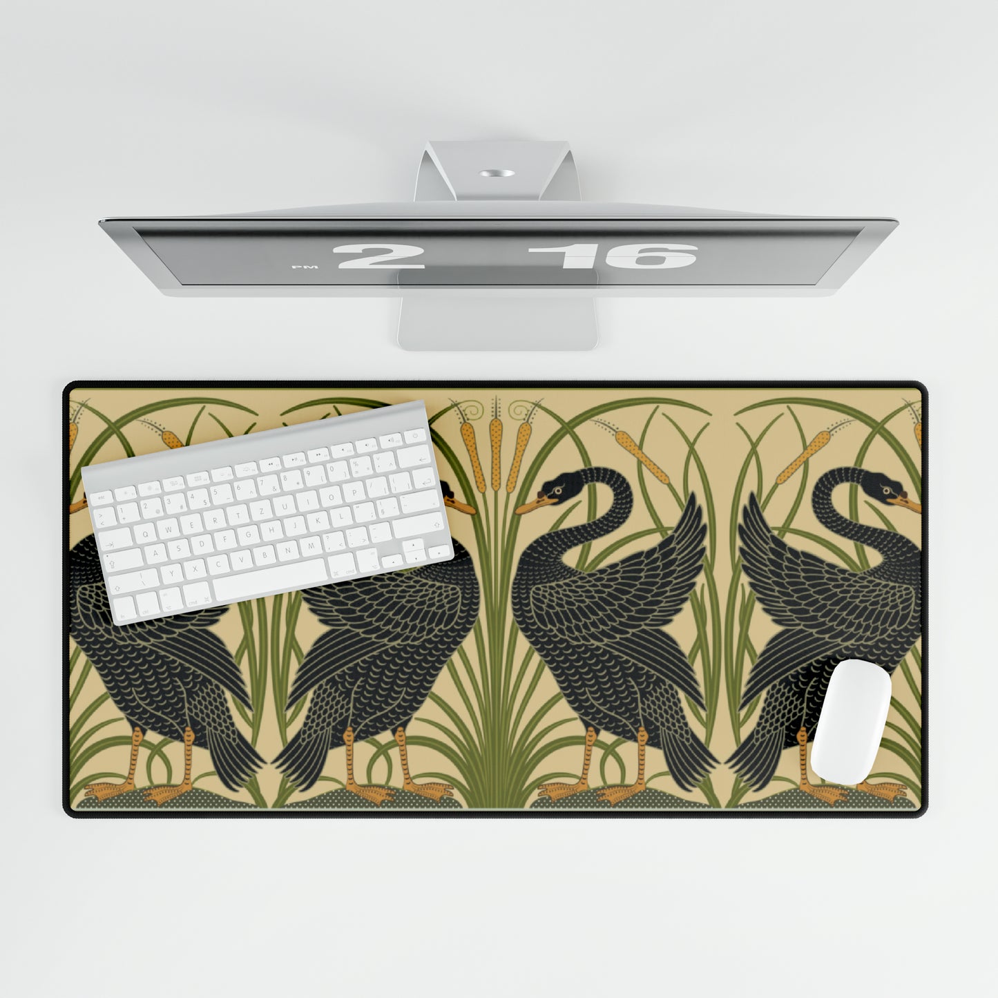 A large desk mat with a pattern of black swans, placed on a desk under a keyboard and a mouse, with a monitor mounted on the desk.