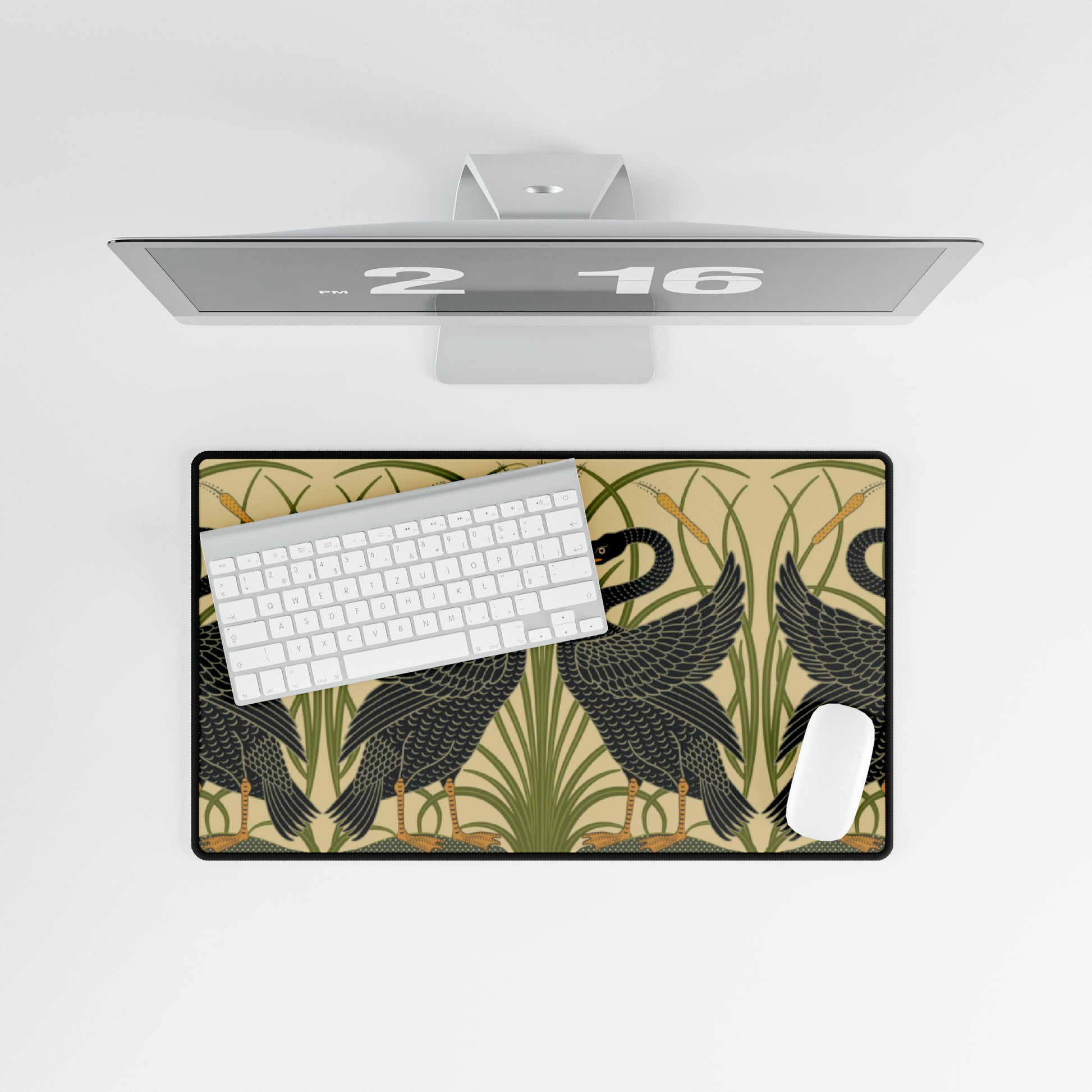 A large desk mat with a pattern of black swans, placed on a desk under a keyboard and a mouse, with a monitor mounted on the desk.