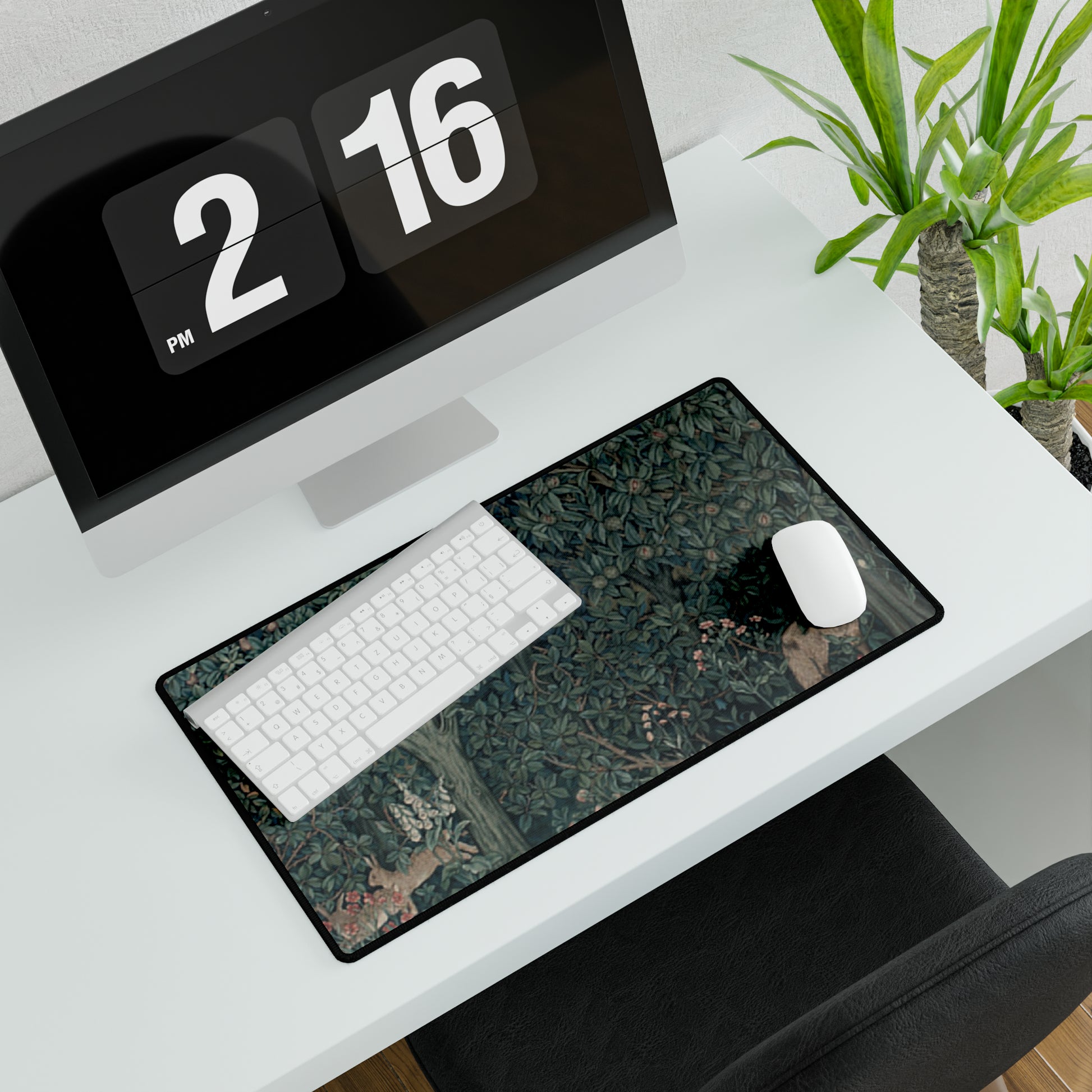 A desk mat with a floral and animal pattern, primarily in green and red colours, featuring a mouse pad on top. The desk mat has a non-slip base and is displayed in a room setting with a monitor, keyboard, and mouse.