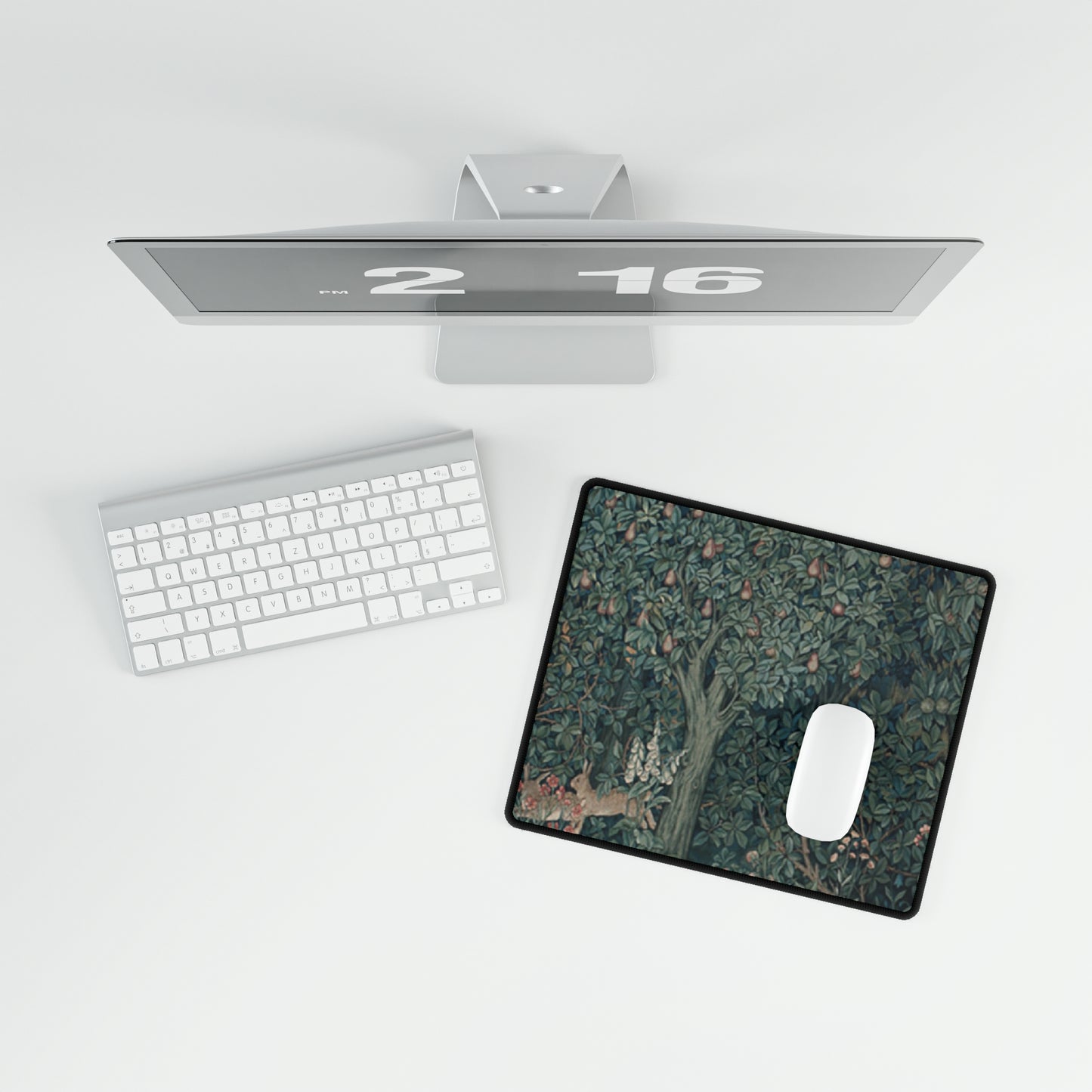 A desk mat with a floral and animal pattern, primarily in green and red colours, featuring a mouse pad on top. The desk mat has a non-slip base and is displayed in a room setting with a monitor, keyboard, and mouse.