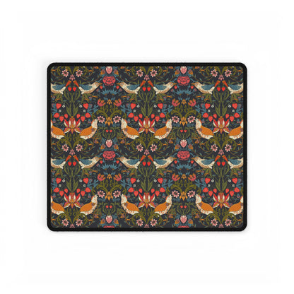A large, rectangular desk mat with a floral pattern featuring birds and flowers, displayed on a desk with a keyboard and mouse.