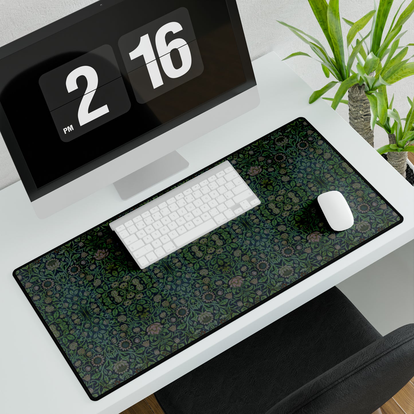 A large desk mat with a floral pattern in green shades, displayed on a desk with a keyboard and mouse.