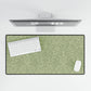 A rectangular desk mat with a green floral pattern, featuring a William Morris & Co oak leaf design, placed under a white desk lamp and a computer mouse on top of the mat.