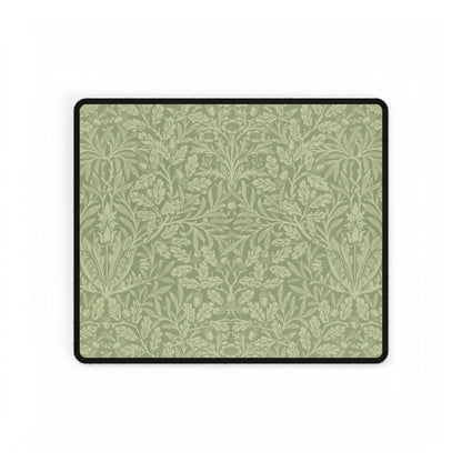 A rectangular desk mat with a green floral pattern, featuring a William Morris & Co oak leaf design, placed under a white desk lamp and a computer mouse on top of the mat.