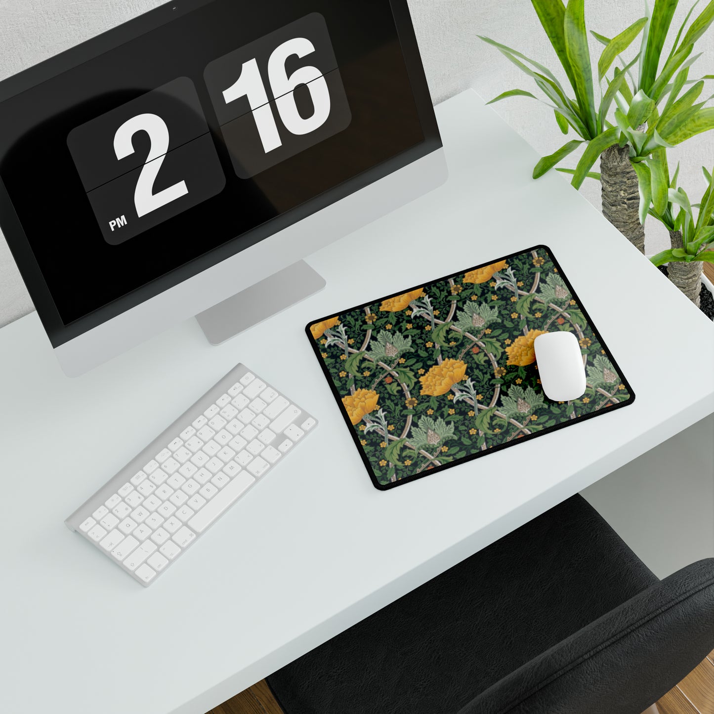 A desk mat with a floral pattern, inspired by William Morris - Chrysanthemum Collection, placed under a desk with a keyboard and mouse on top.