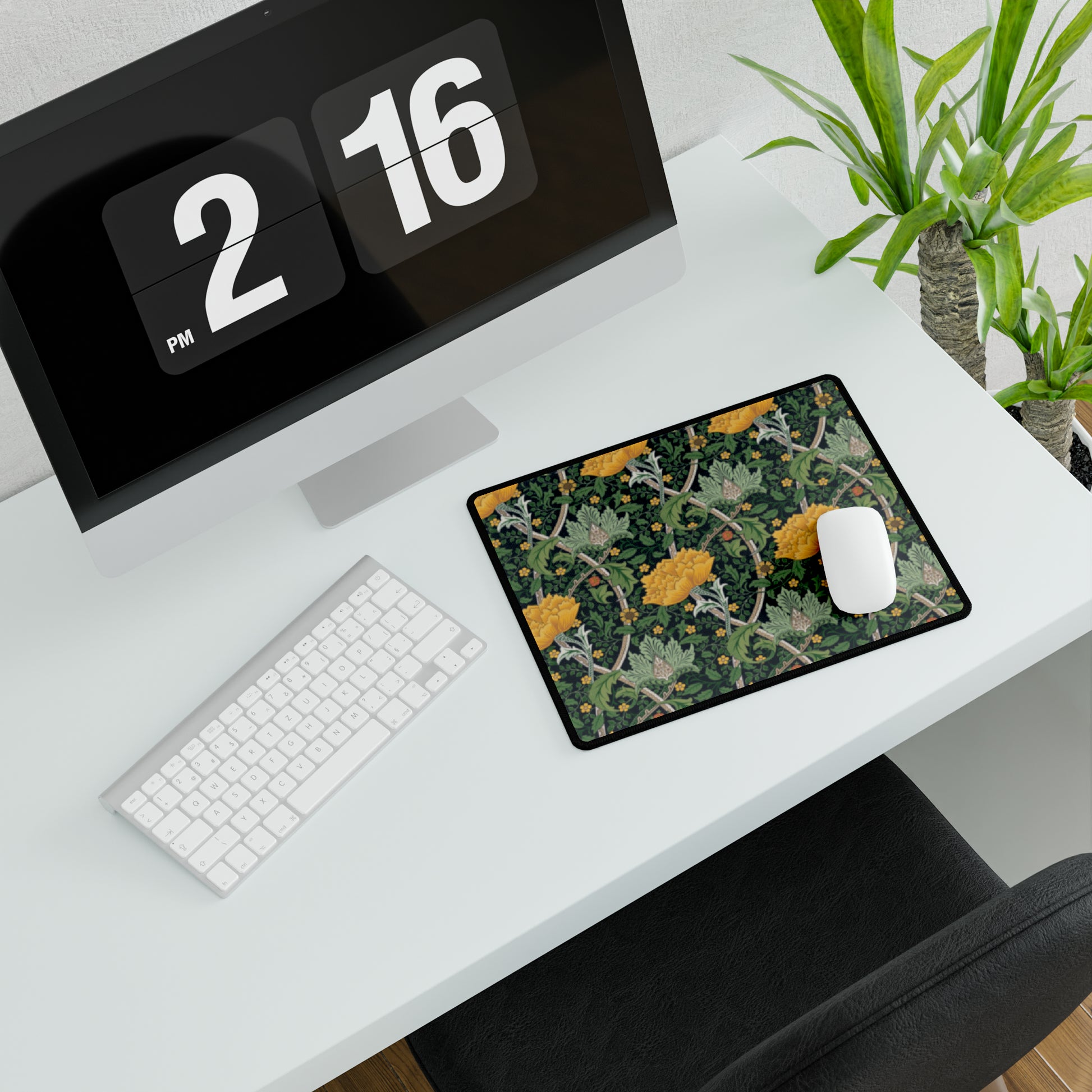 A desk mat with a floral pattern, inspired by William Morris - Chrysanthemum Collection, placed under a desk with a keyboard and mouse on top.