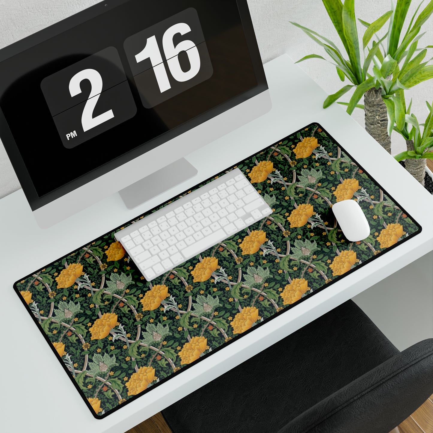 A desk mat with a floral pattern, inspired by William Morris - Chrysanthemum Collection, placed under a desk with a keyboard and mouse on top.