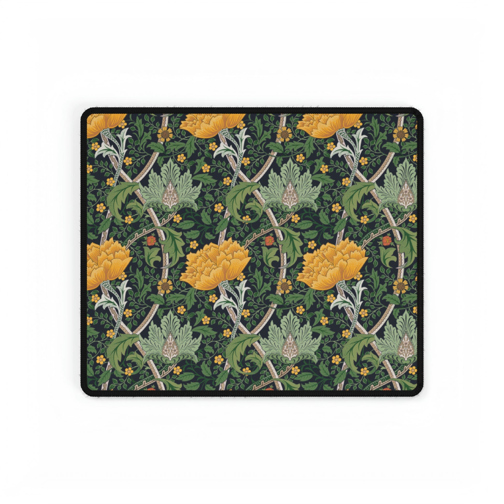 A desk mat with a floral pattern, inspired by William Morris - Chrysanthemum Collection, placed under a desk with a keyboard and mouse on top.