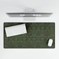 A rectangular desk mat with a floral garden pattern, placed under a desk with a keyboard and mouse on top.