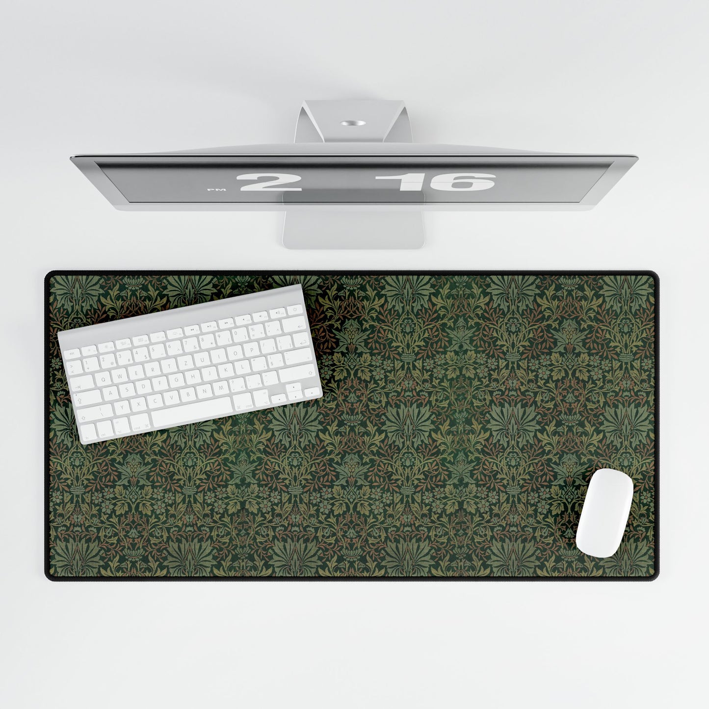 A rectangular desk mat with a floral garden pattern, placed under a desk with a keyboard and mouse on top.
