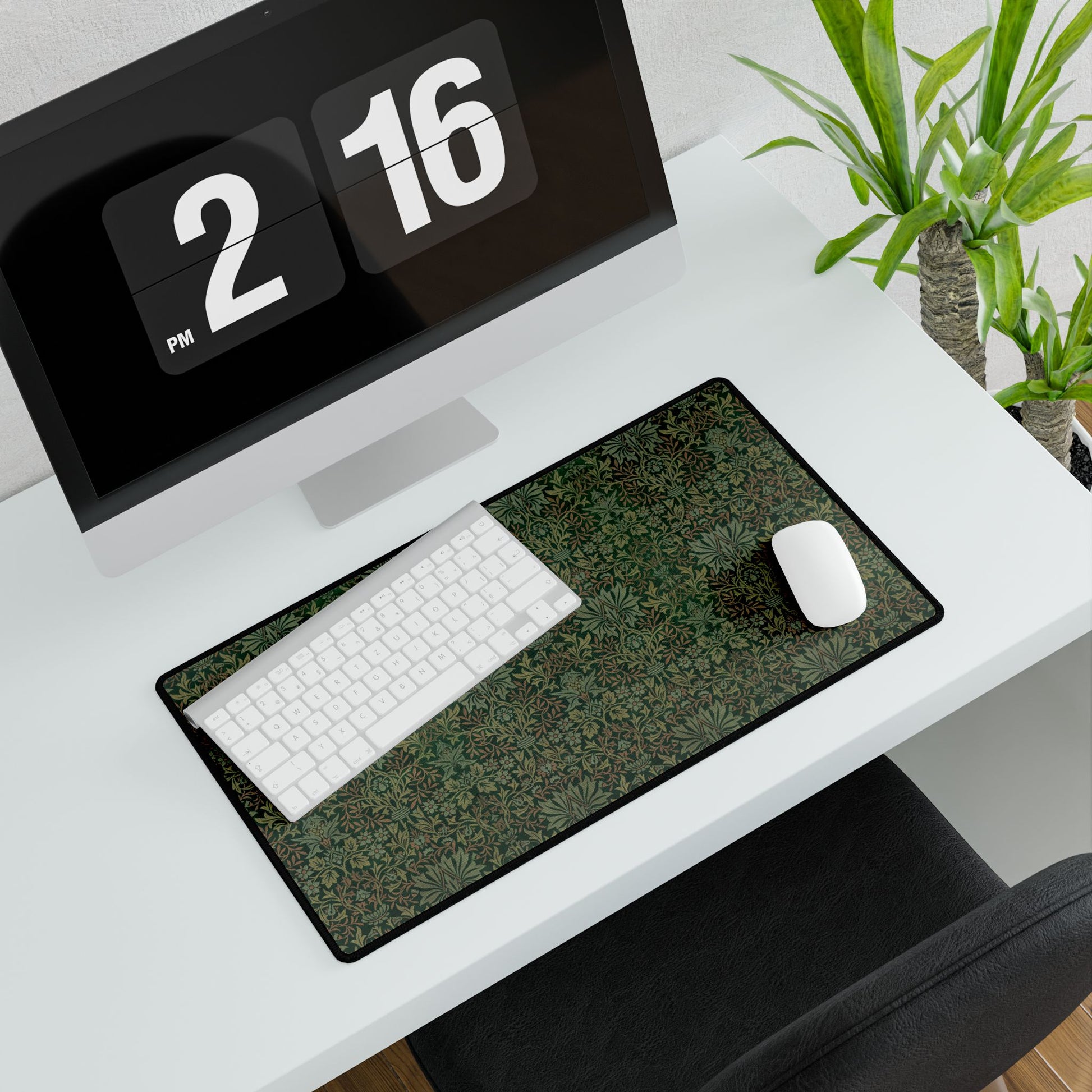 A rectangular desk mat with a floral garden pattern, placed under a desk with a keyboard and mouse on top.