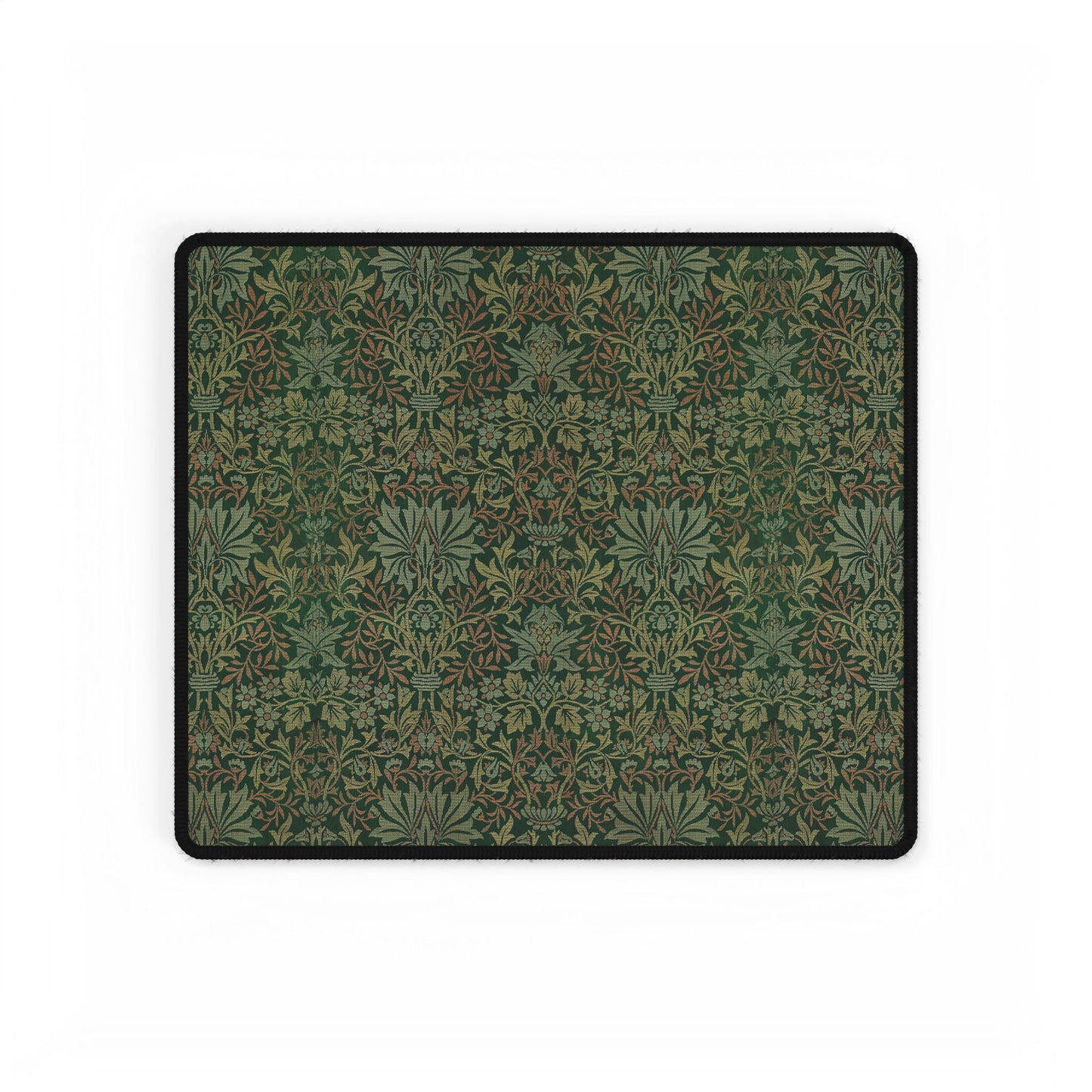 A rectangular desk mat with a floral garden pattern, placed under a desk with a keyboard and mouse on top.