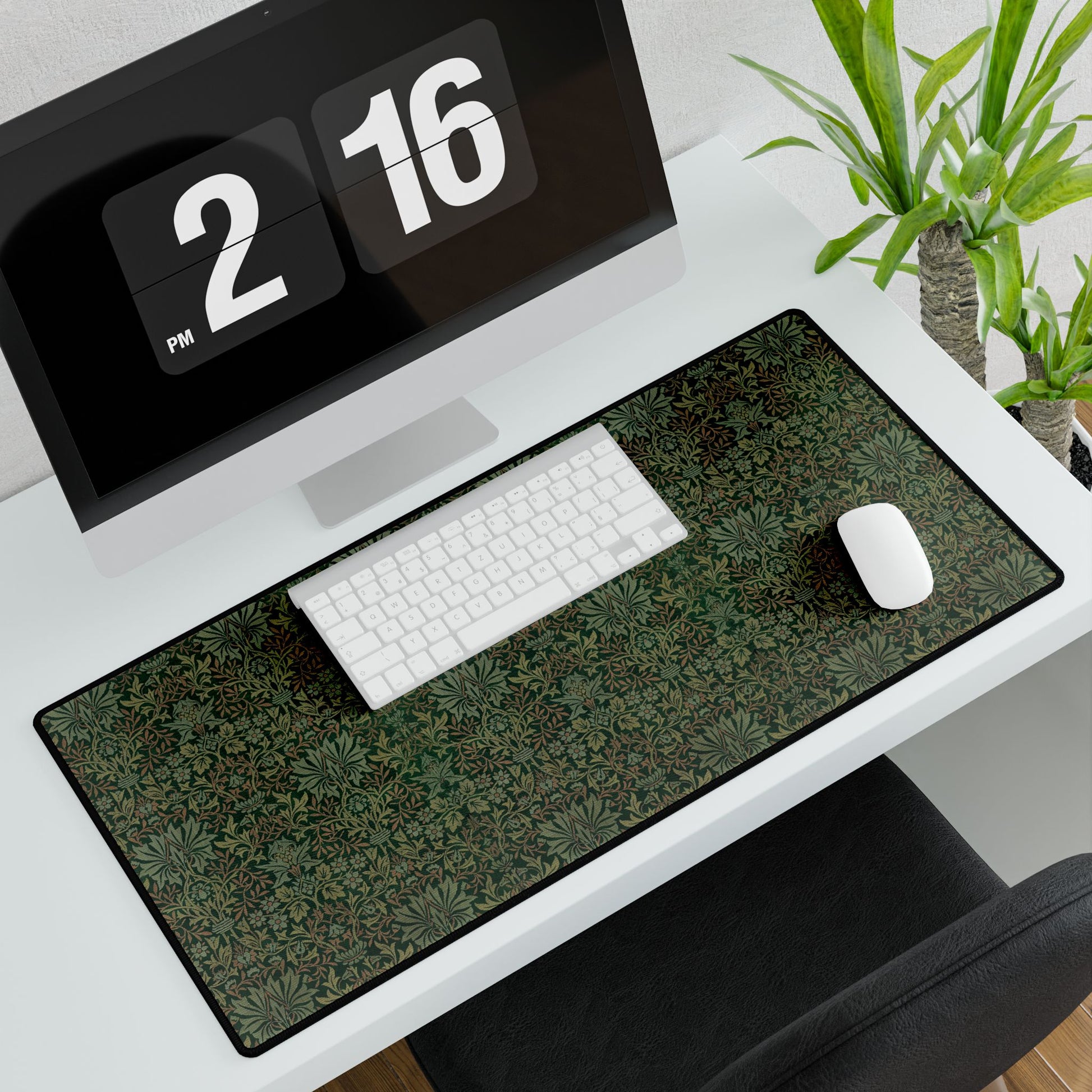 A rectangular desk mat with a floral garden pattern, placed under a desk with a keyboard and mouse on top.