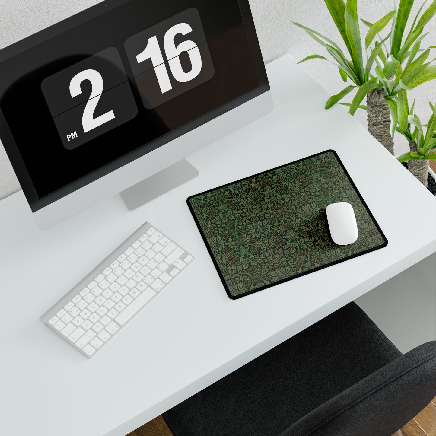 A rectangular desk mat with a floral garden pattern, placed under a desk with a keyboard and mouse on top.