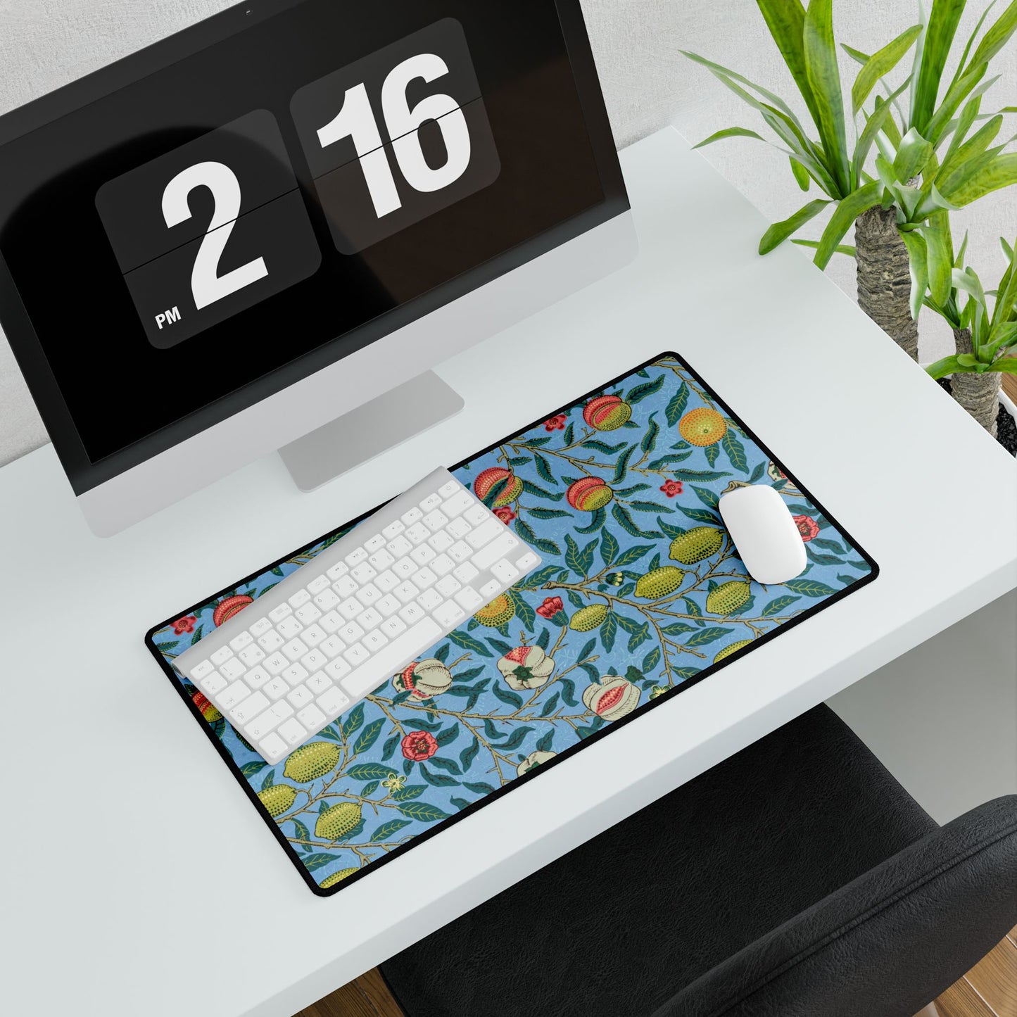 A desk mat with a floral pattern featuring various fruits, placed under a desk with a keyboard and mouse on top.