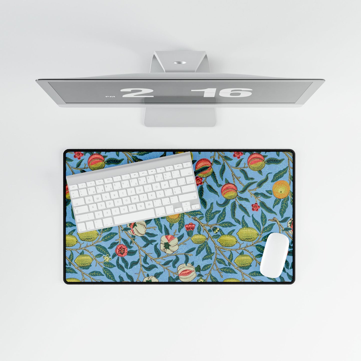A desk mat with a floral pattern featuring various fruits, placed under a desk with a keyboard and mouse on top.